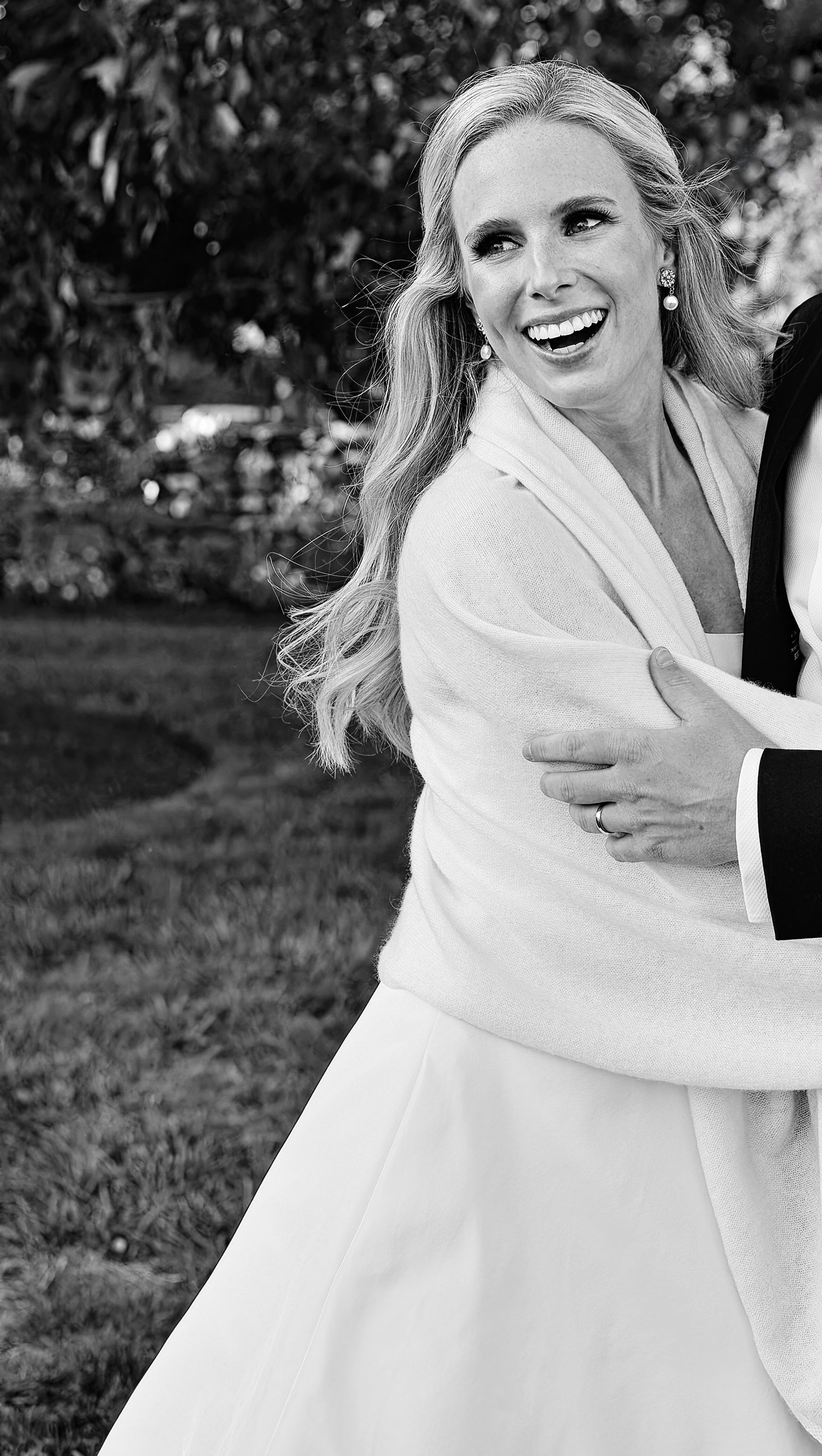 Joyous candid portrait of bride while wrapped in the arms of the groom in Jamestown, RI.
