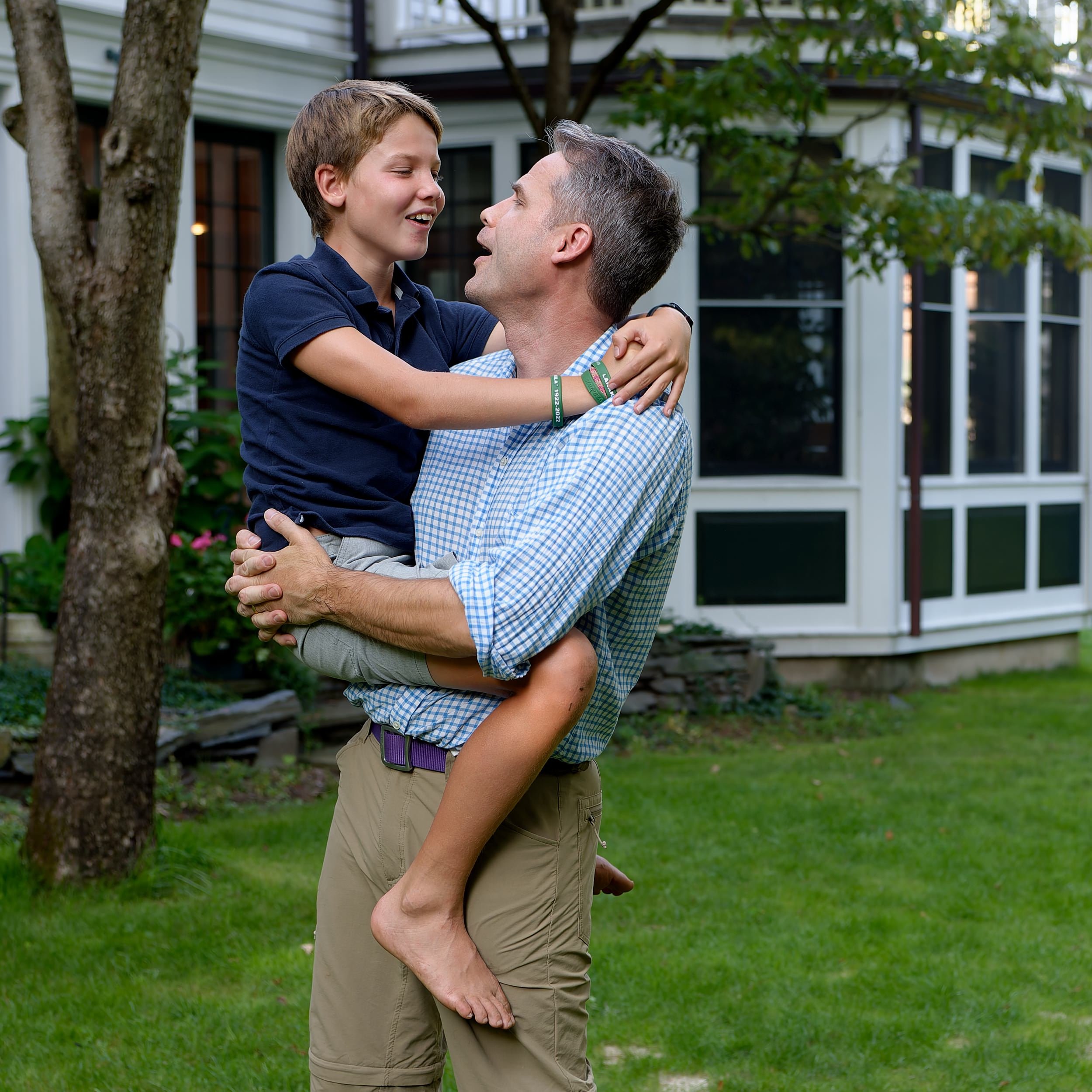 Father hugging his son outside the family home.