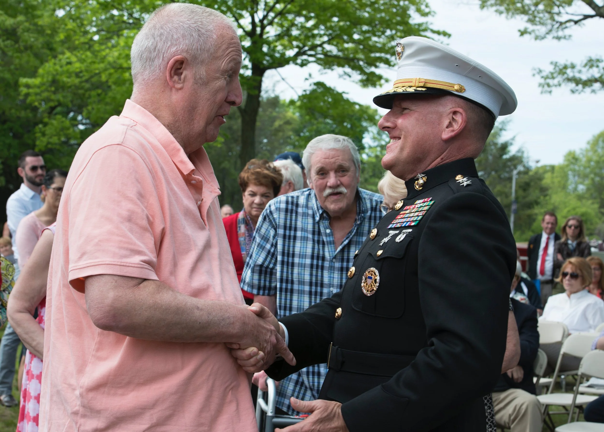 Veteran greeting another attendee during the 21 Heroes Memorial gathering.