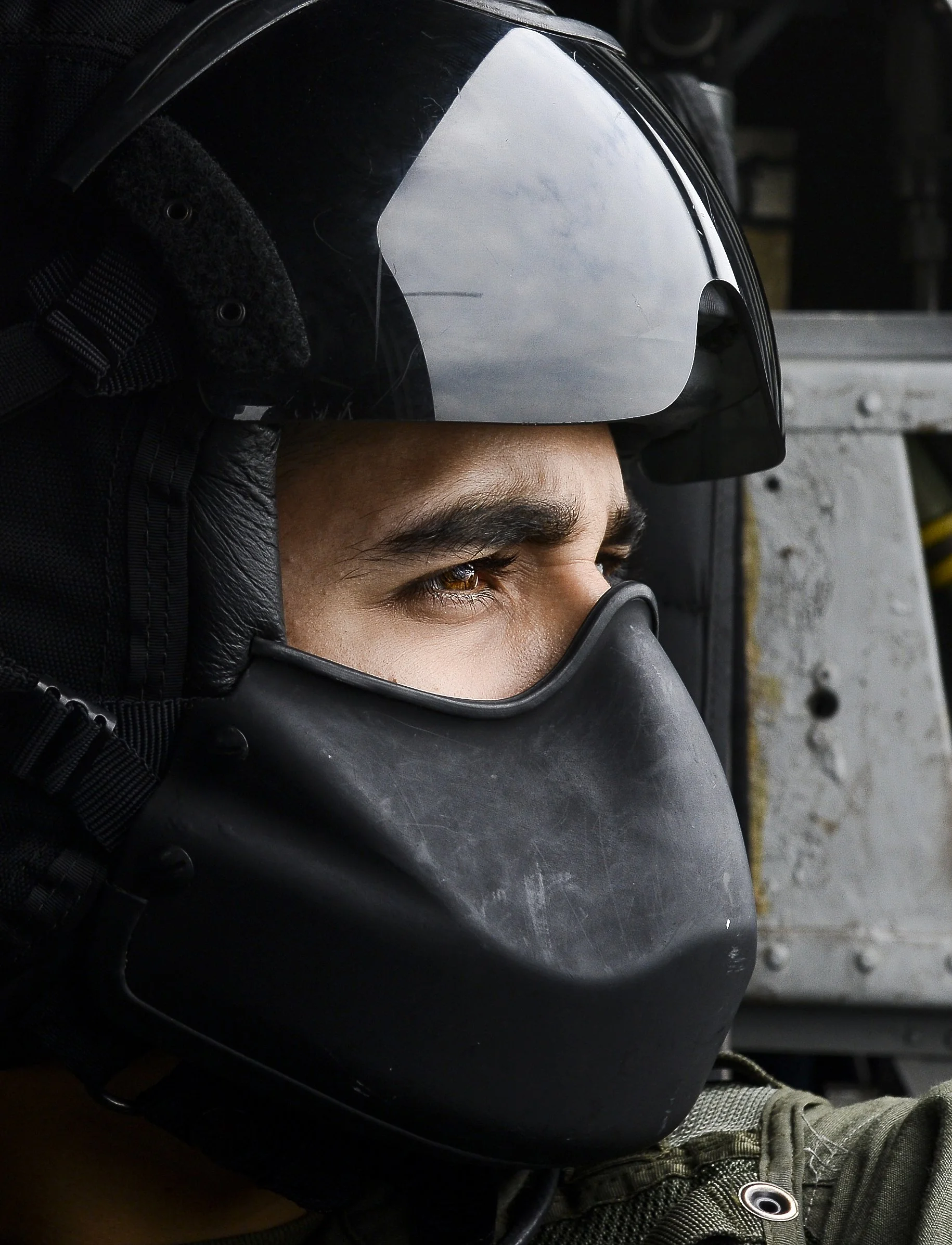 Portrait of a Crew Chief Pilot looking out the window of a military helicopter while flying above northern virginia and Washington, DC.