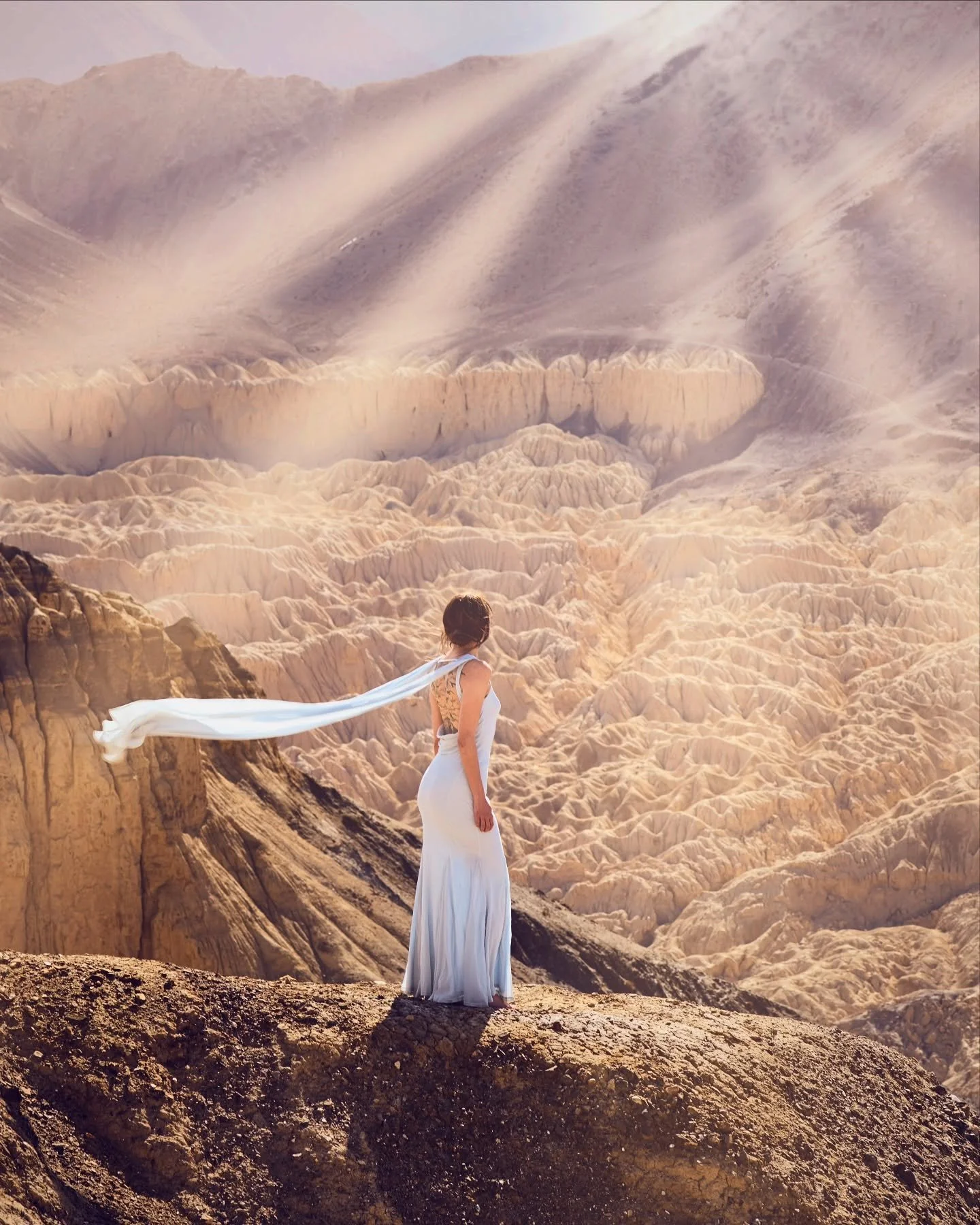 Draped in silence and soft light, Kristen stands above the moonscape of Lamayuru — a place often called “Moonland” for its otherworldly textures and golden folds. Located in Ladakh, India, this ancient village is carved into time an