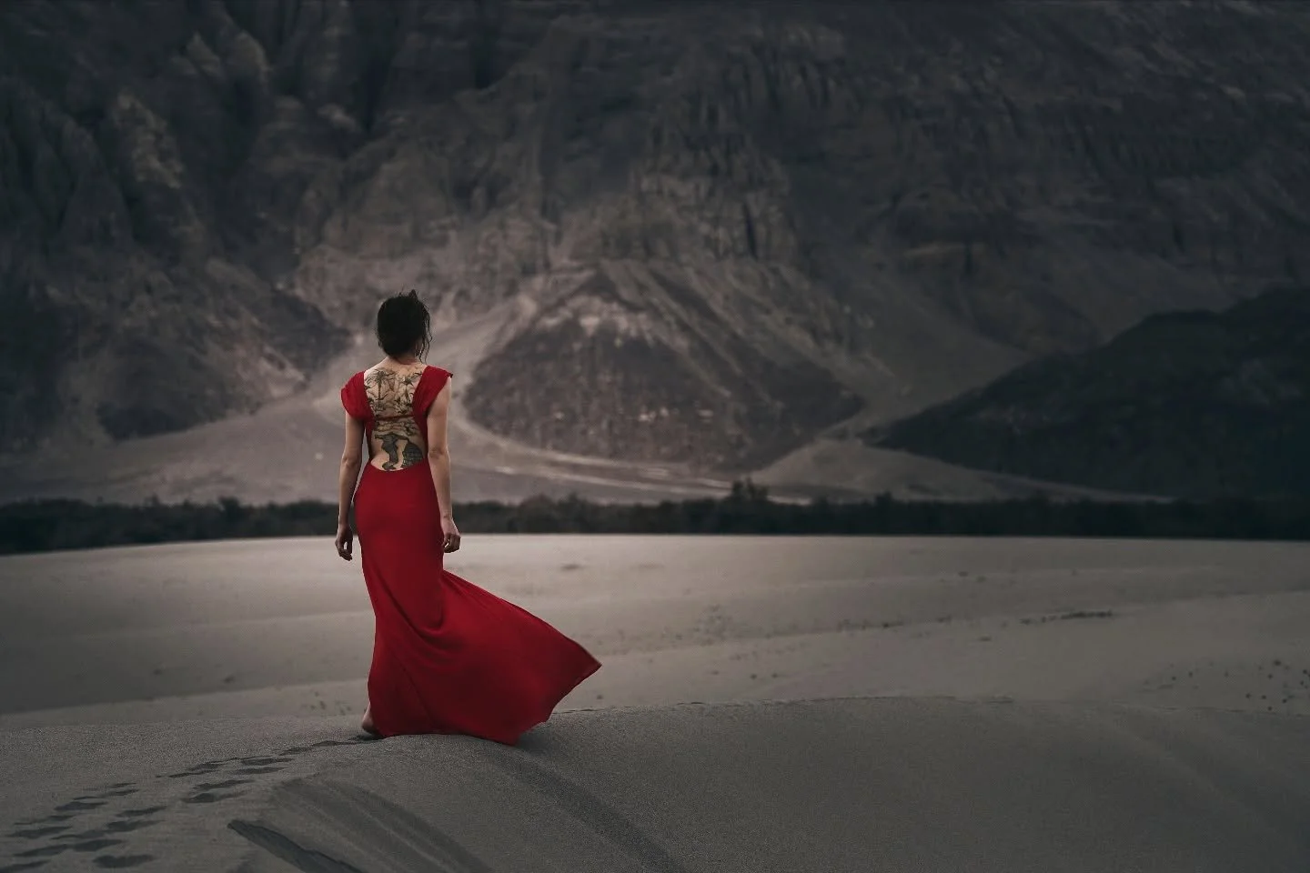 A scarlet thread woven through the silence of the dunes.
In Ladakh&rsquo;s high desert, time stands still &mdash; only the wind and mountains bear witness.

The lovely Kristen carried a quiet strength through this landscape, her presence a reflection