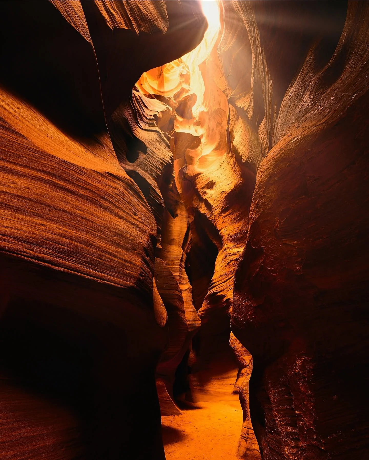 The canyon speaks in curves and whispers,
its walls carved by centuries of thunderous flash floods&mdash;
a painter&rsquo;s palette of reds and golds shaped by storm and silence.

Here, sunlight filters like fire through stone,
illuminating the sacre