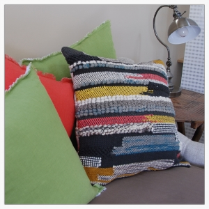 Whether neutral or bright, color and textiles can enhance a space and speak to the user's personality. An office daybed gets some personality with bright linen and tactile, imported wool pillows.