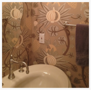 Once painted oxblood red, powder room still has impact, but now with more interest. Small spaces can have big appeal with large-scale wall pattern. While the pattern is bold, the neutral color palette keeps it reserved.