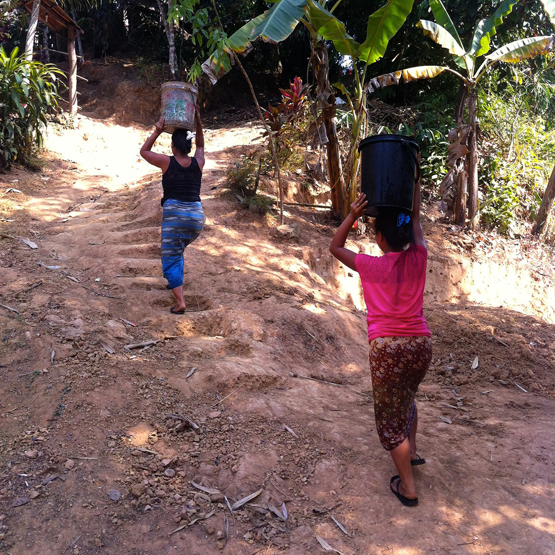 Women carrying water back to their houses (Song Ka Lia community)
