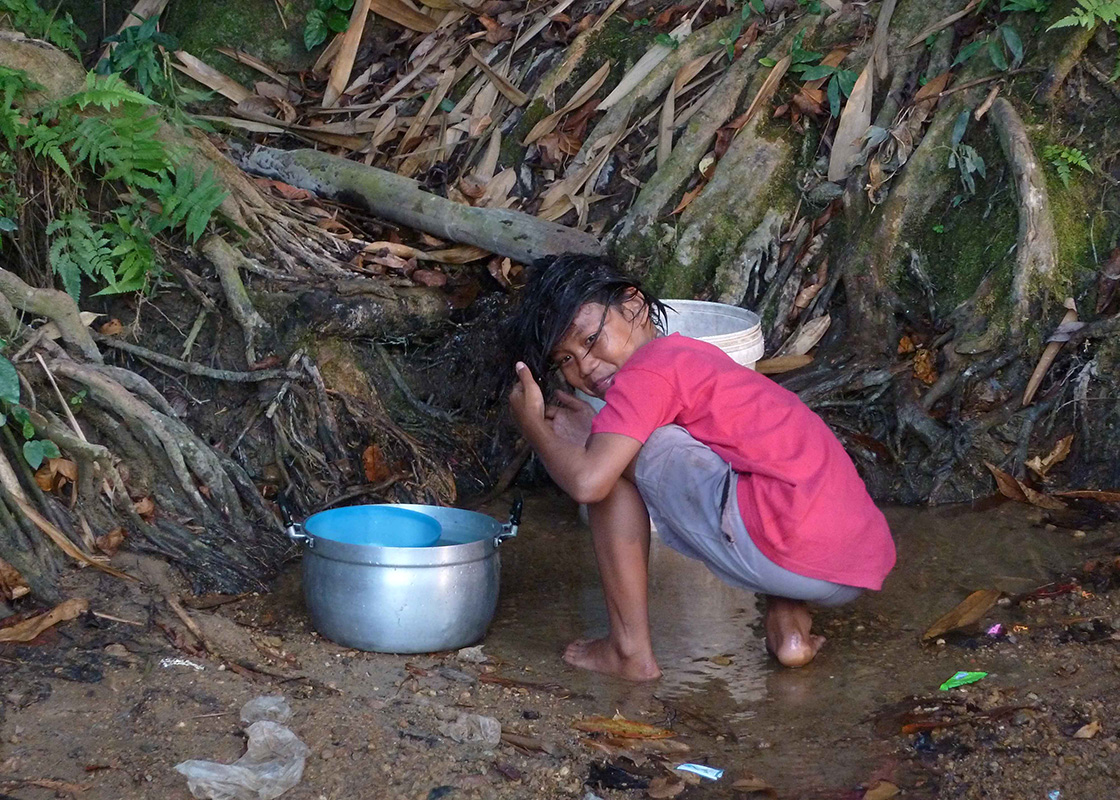 A girl collecting water and washing her hair
