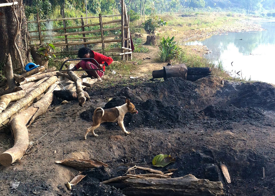 A girl taking a day off from school to help her family make charcoals