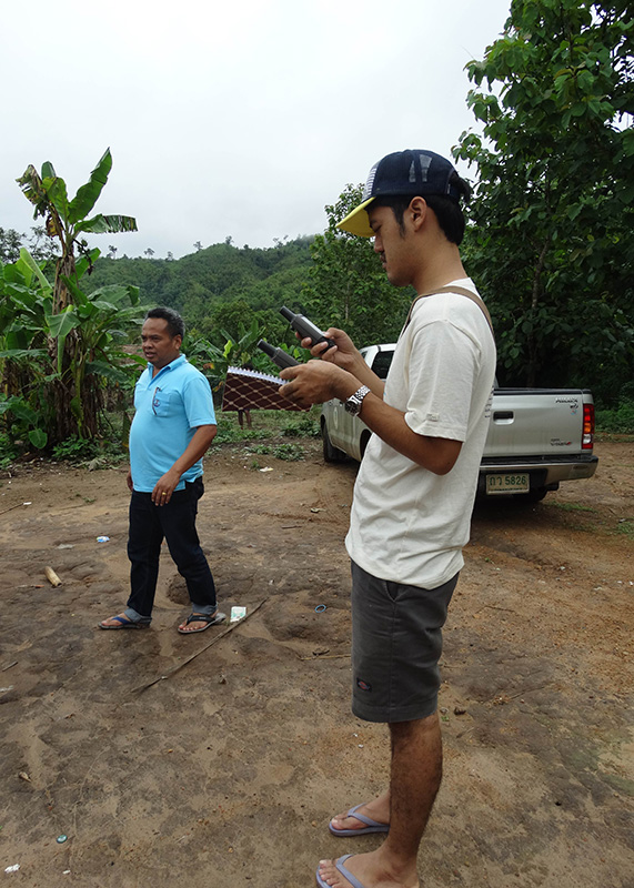 Sutthisak marking key landmarks on the GPS while visiting the communities
