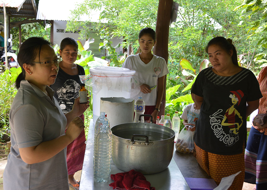 Apinya demonstrating how to use chlorine to disinfect water.