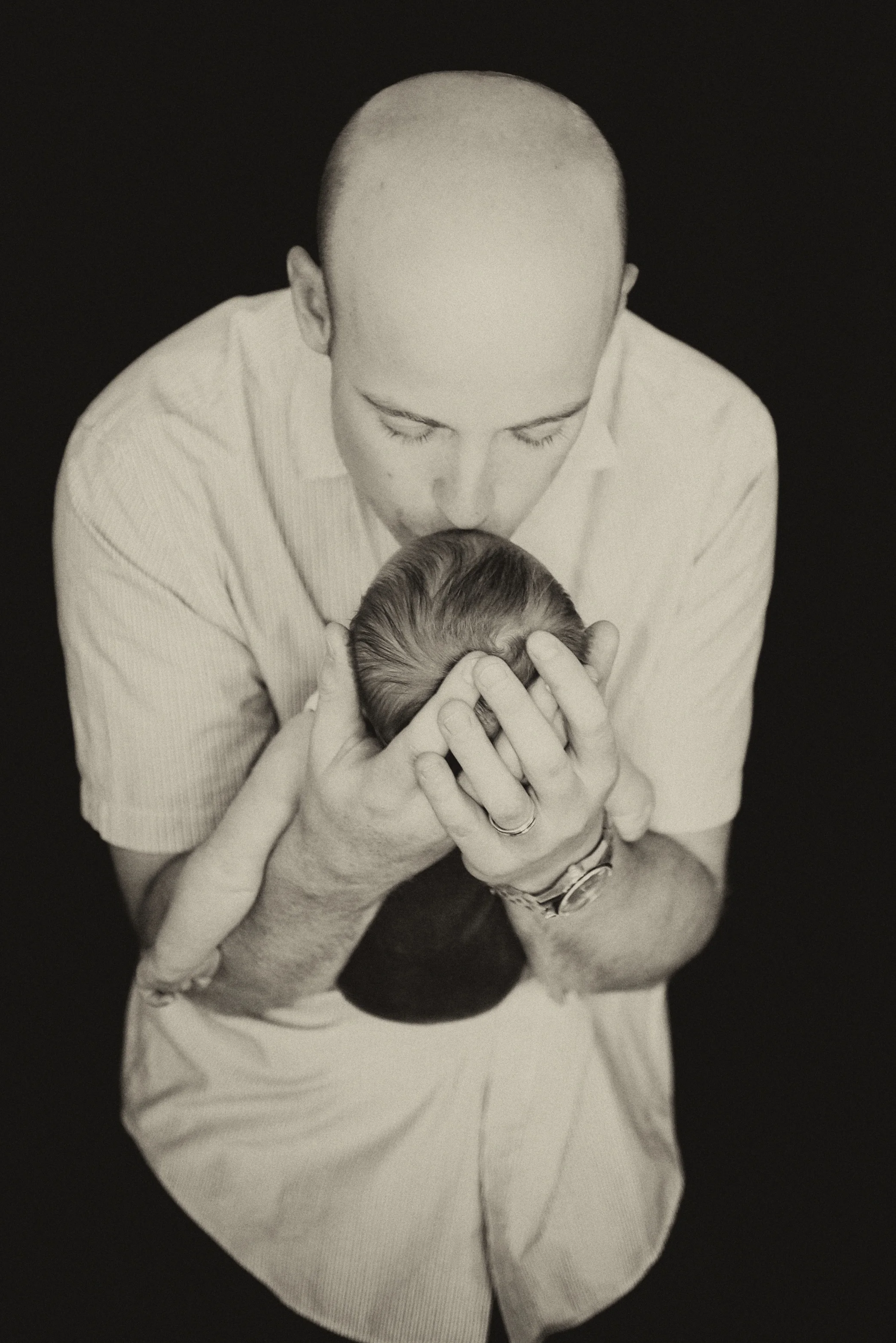 A picture of a dad kissing his baby on the forehead. Image Taken by Warnock Imagery