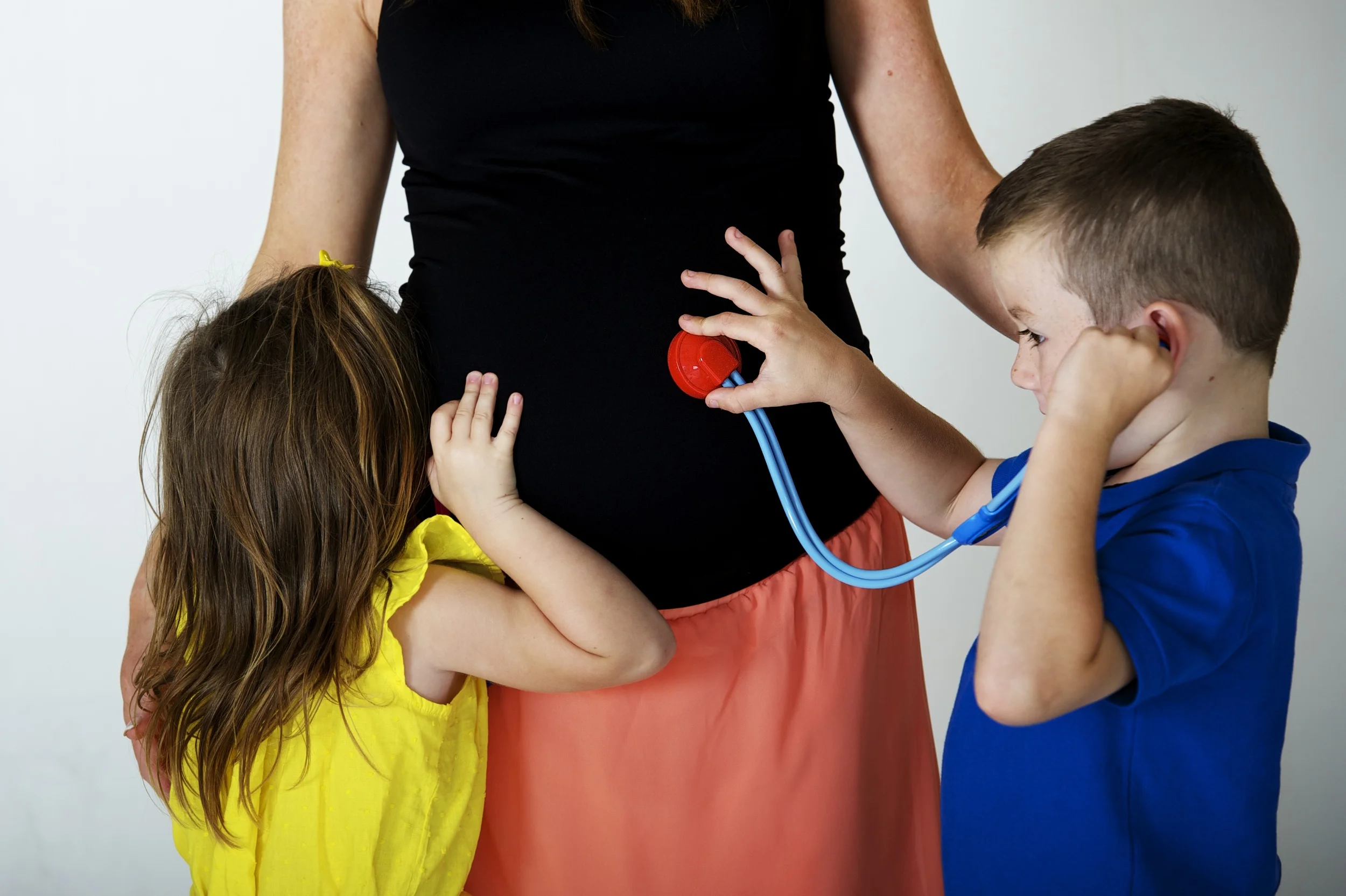 This is a fun Maternity Image with big brother and sister to be playing doctor on Mums belly. Image Taken by Warnock Imagery
