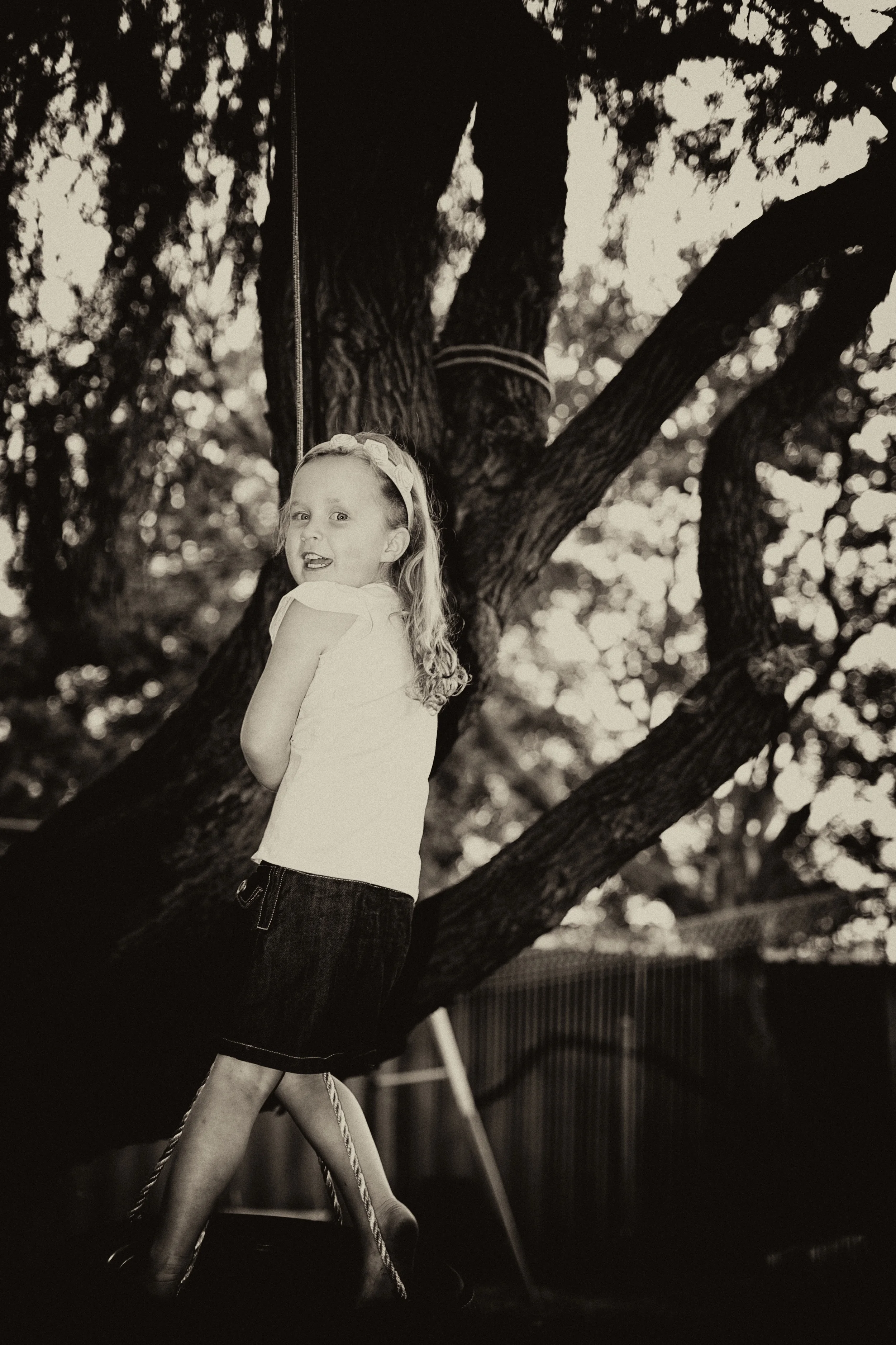 A little girl plays on her swing during this family photo in Perth