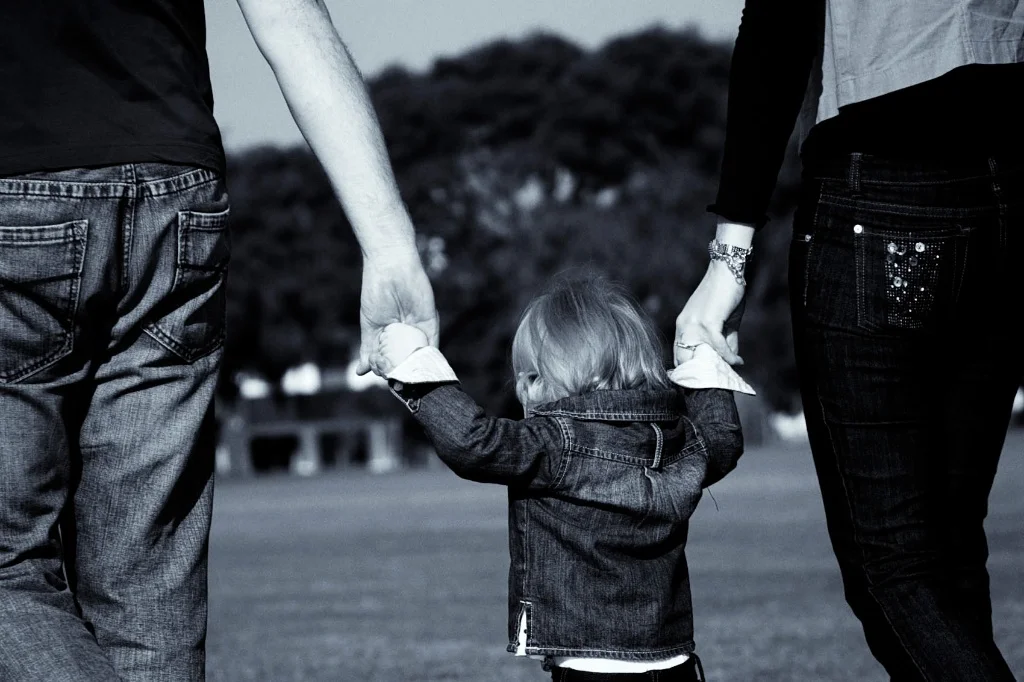 Mum and dad hold their childs hand in this great family photography. Image taken by Warnock Imagery