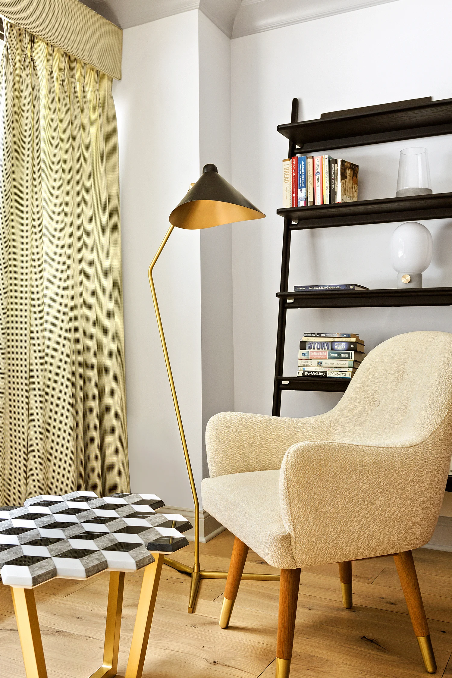 Reading area. Diplopia marble table, dandy chair, brass floor lamp and black stained wooden library with Kvadrat curtains.