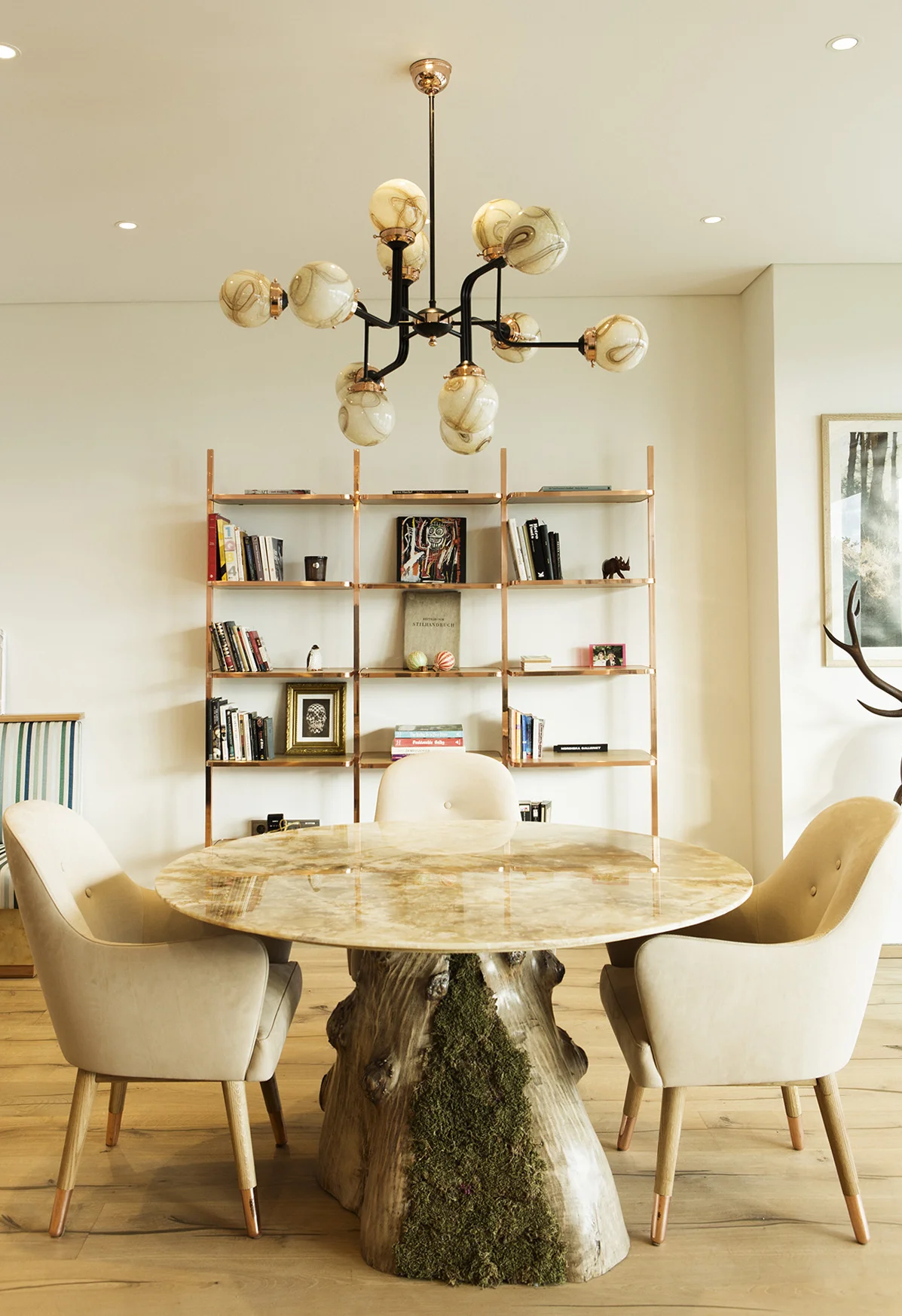 Dining Area. Custom designed onyx marble table with split root and moss, dandy chairs, cyclopedia bookshelf.