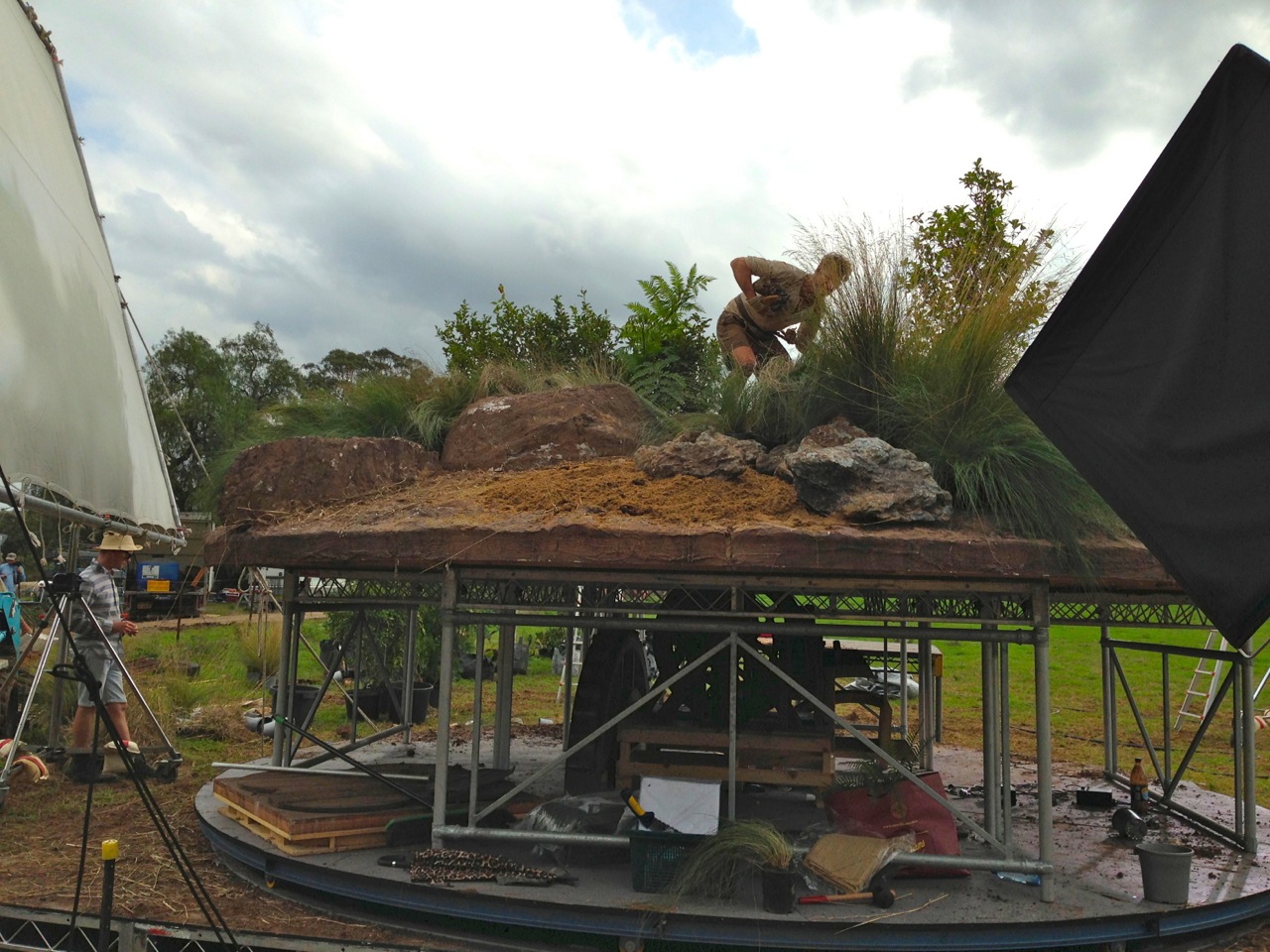 Full scale section of top of boulder built on elevated turntable to simulate turning planet shoot empty then progressively dressed with plants and small boulders
