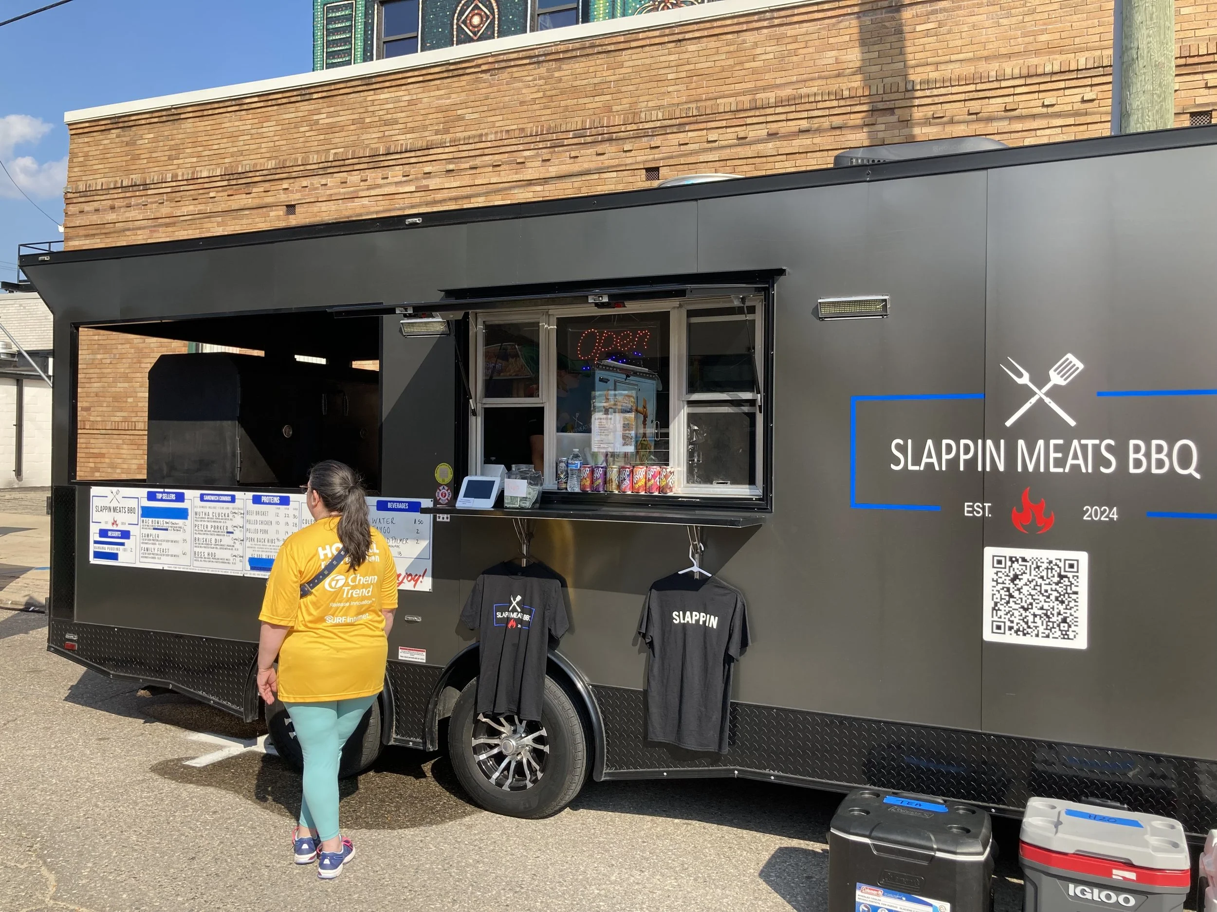 A photo of a person waiting in line for the Slappin' Meats BBQ truck.