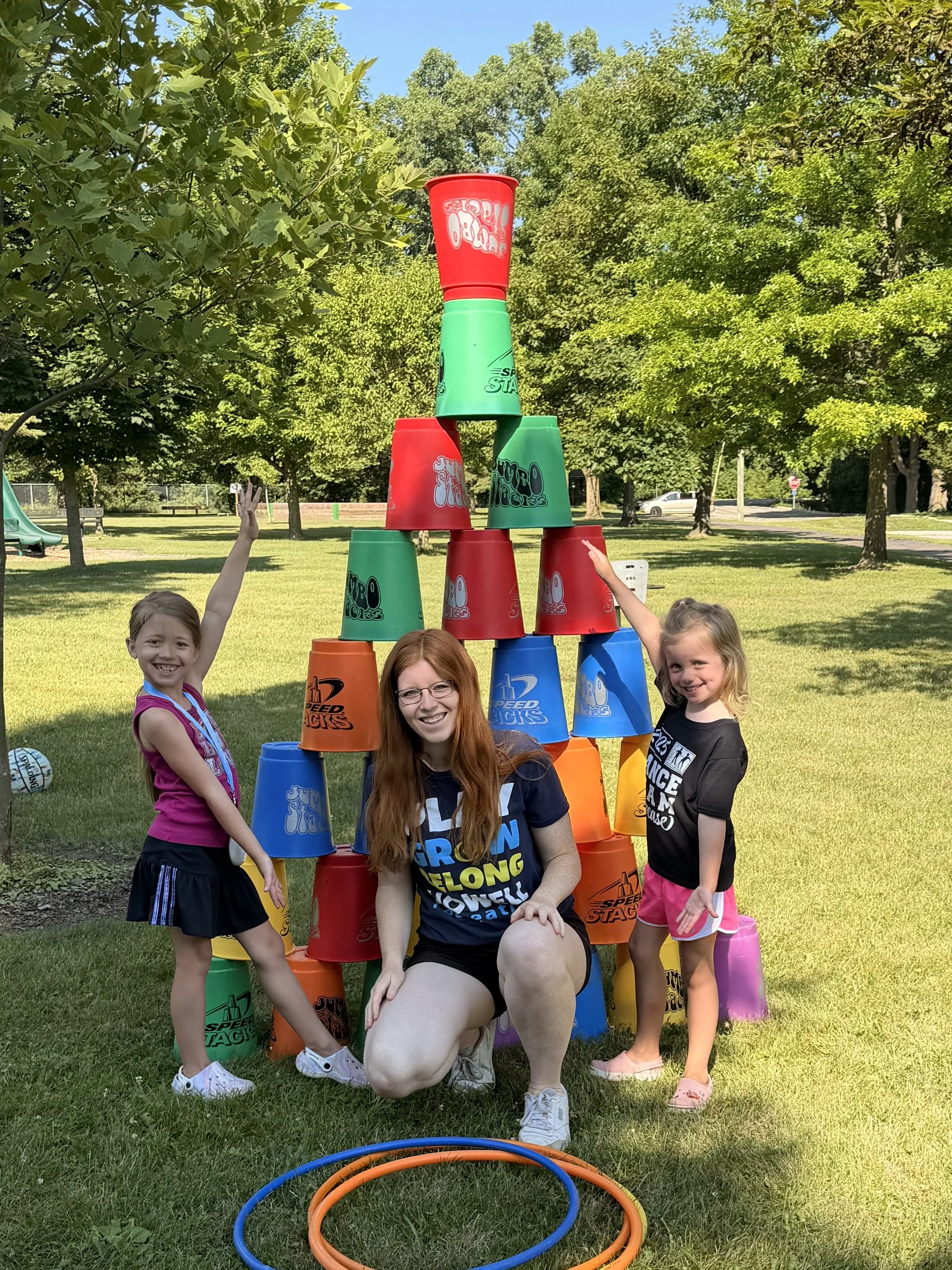Two little girls show off their giant stacking up tower with one of the Rec on the Go staff.