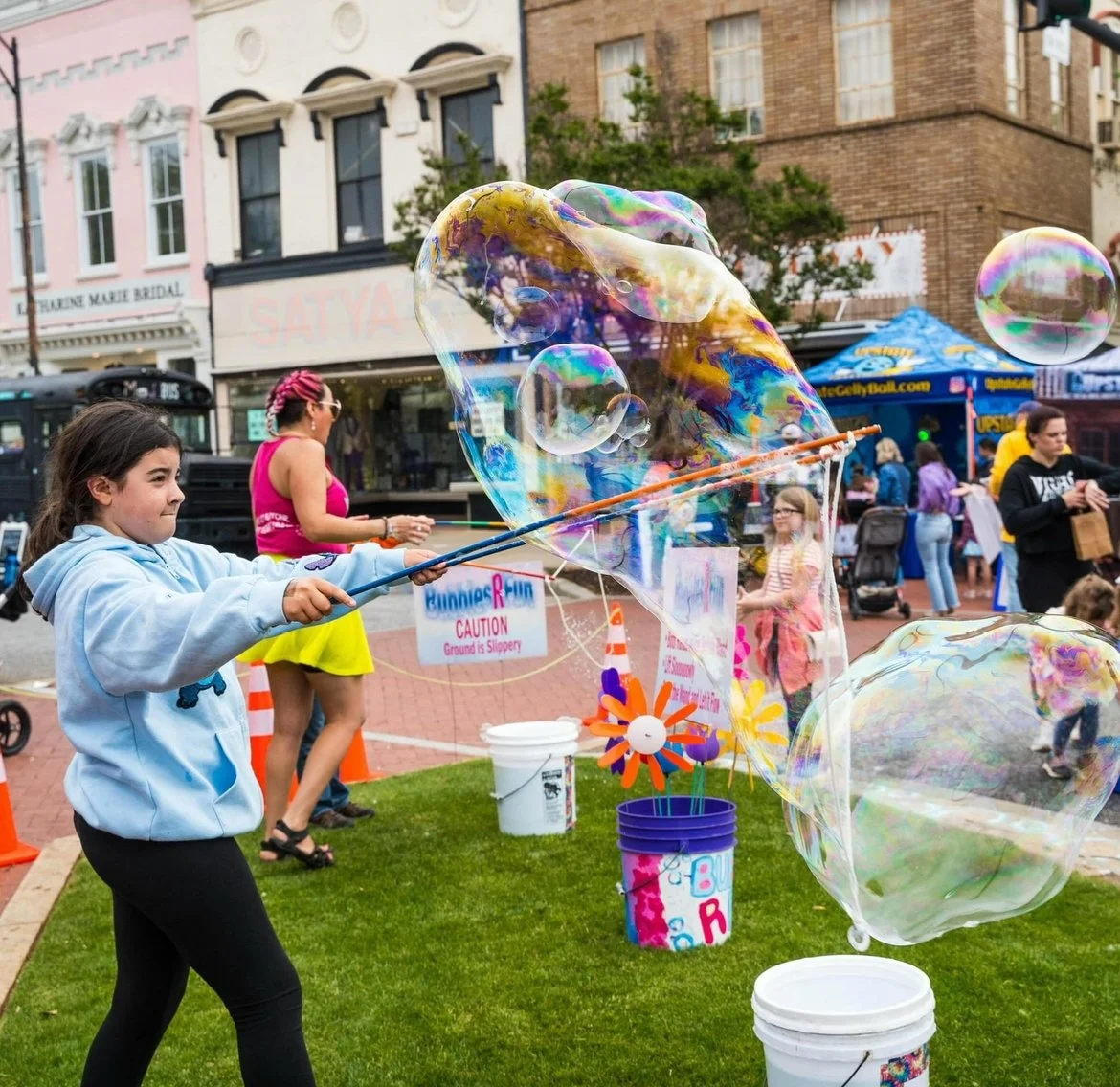 A photo of kids making giant bubbles with custom bubble wands.