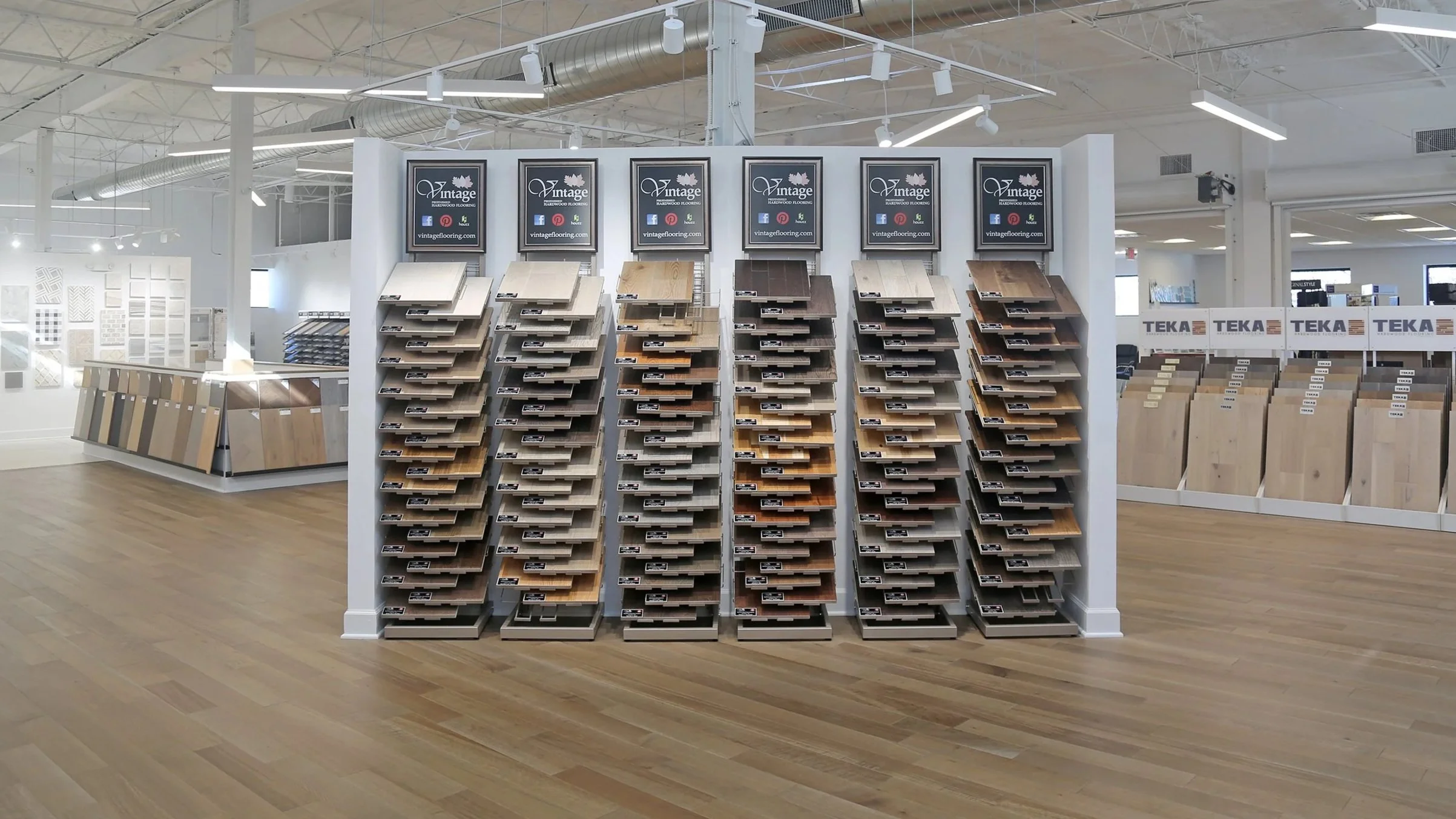 Showroom with hardwood flooring displays, bright lighting and vaulted ceilings.