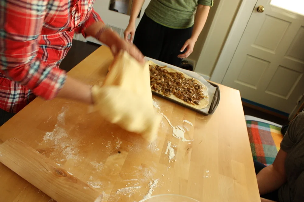  Lifting the dough to place on top of filling. 
