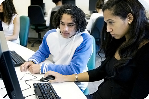 Two students working together on an assignment using a computer at the commuter lab.
