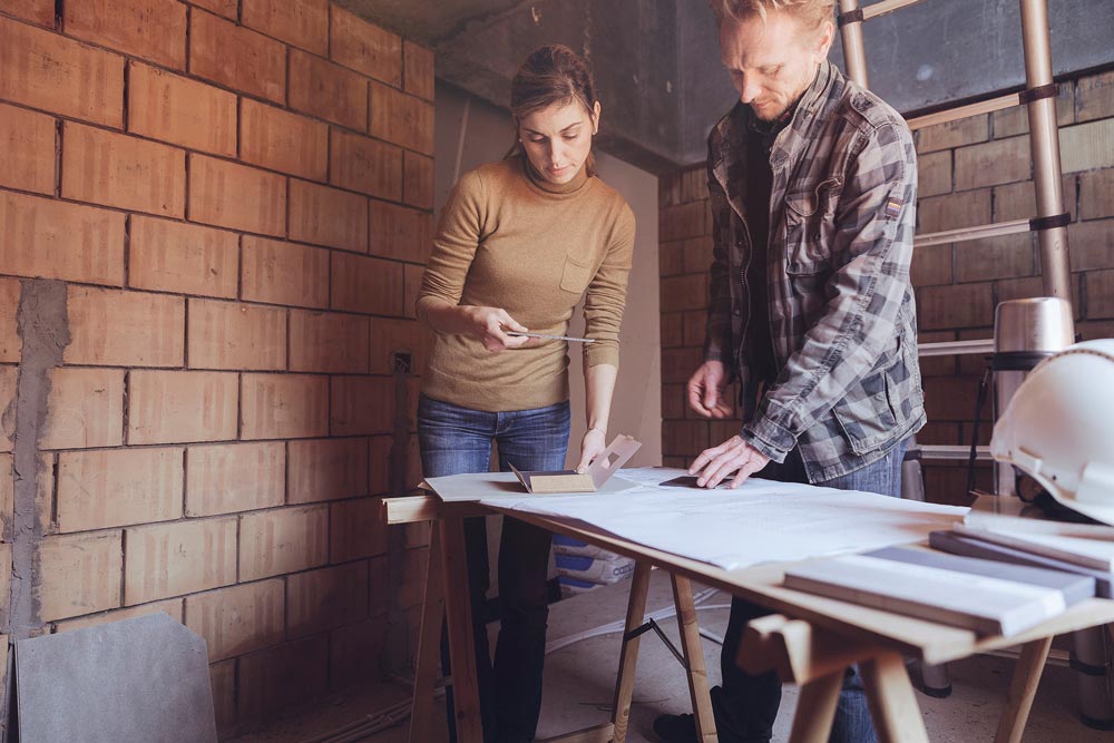 Two people at construction site looking at samples