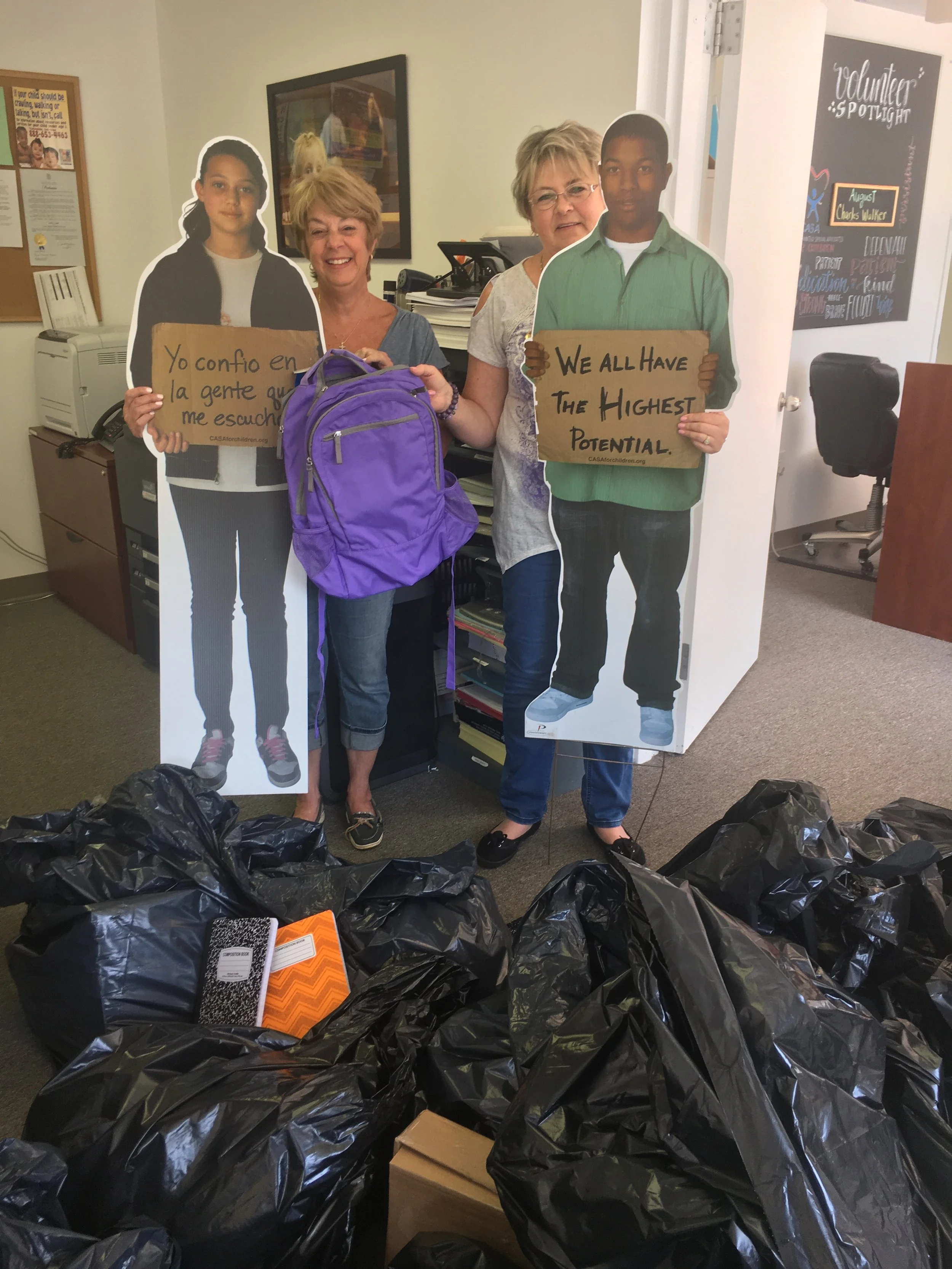 Volunteer Coordinator Margaret Curreri accepts school supply donations from Jean Dingman of the Illuminations Club at Four Seasons at Great Notch. 
