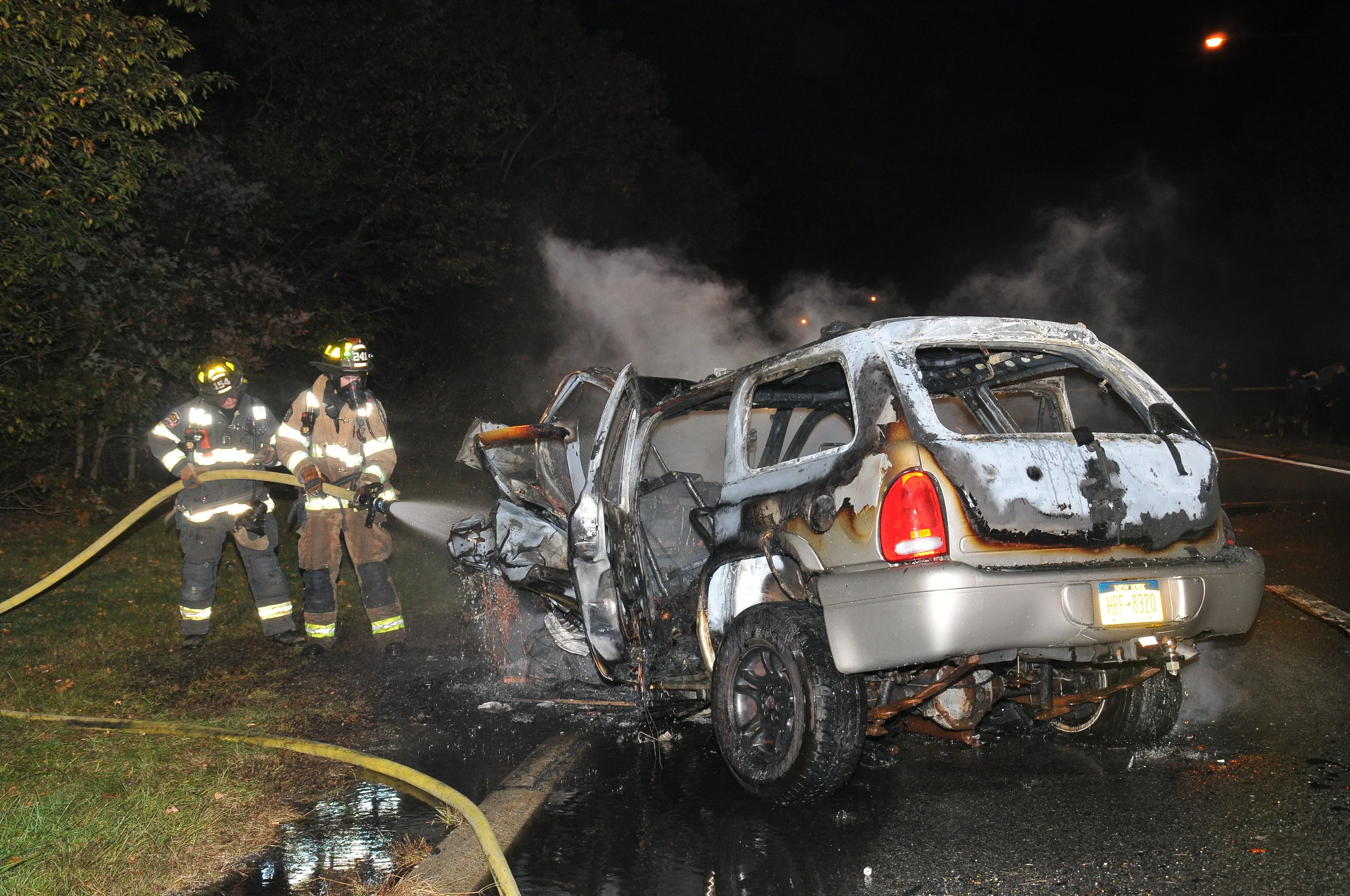 Dix Hills Firefighters extinguish a SUV that was involved in a wrong-way crash that killed two people on the Northern State Parkway in Dix Hills on Oct. 20. Photo credit: Steve Silverman.