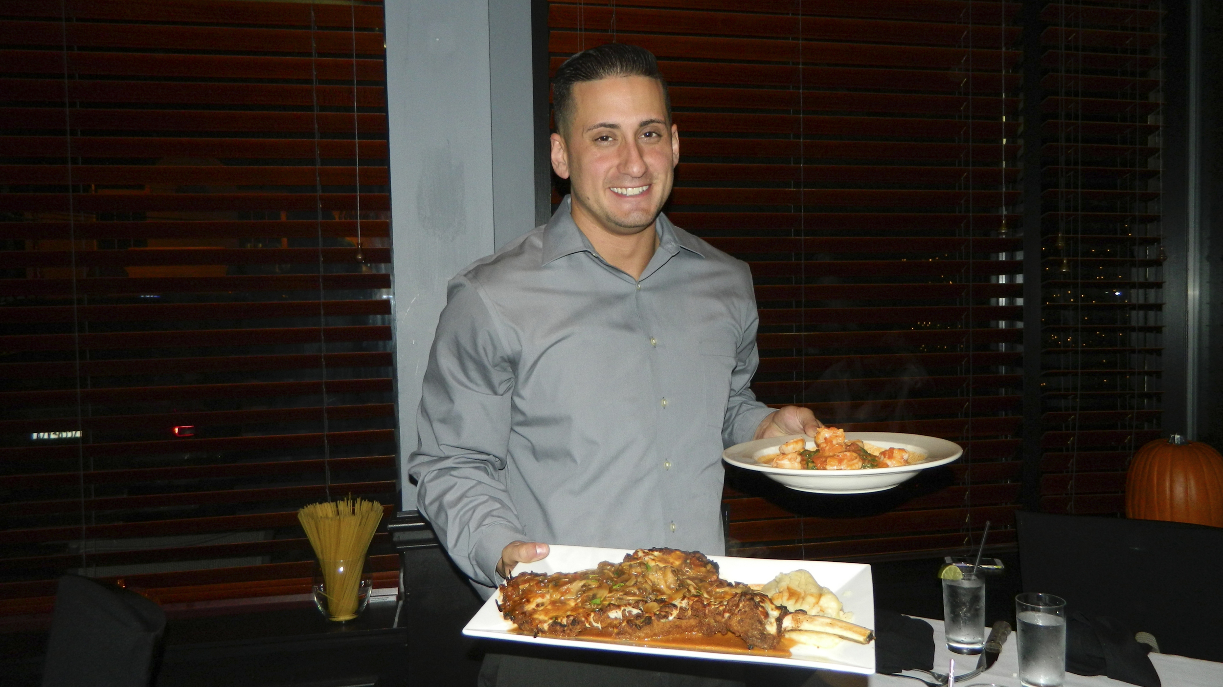 Andrea’s 25 Manager Tyson Loverro presents veal chop and shrimp Luciano entrees.