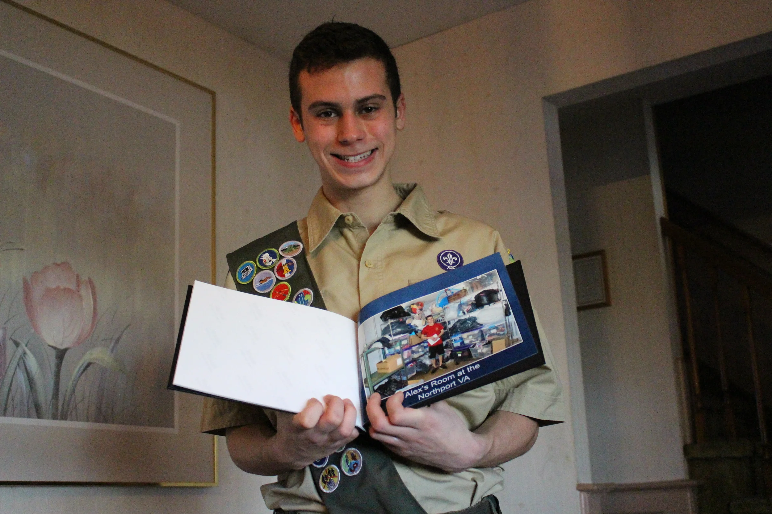 Eagle Scout Kyle Sambolin is all smiles holding up a photo that was taken of himself in the Northport VA donation room, after he helped to revitalize the room that had suffered from flood damage. Sambolin will be receive his Eagle Scout Award at the Huntington Elks Lodge on Monday.