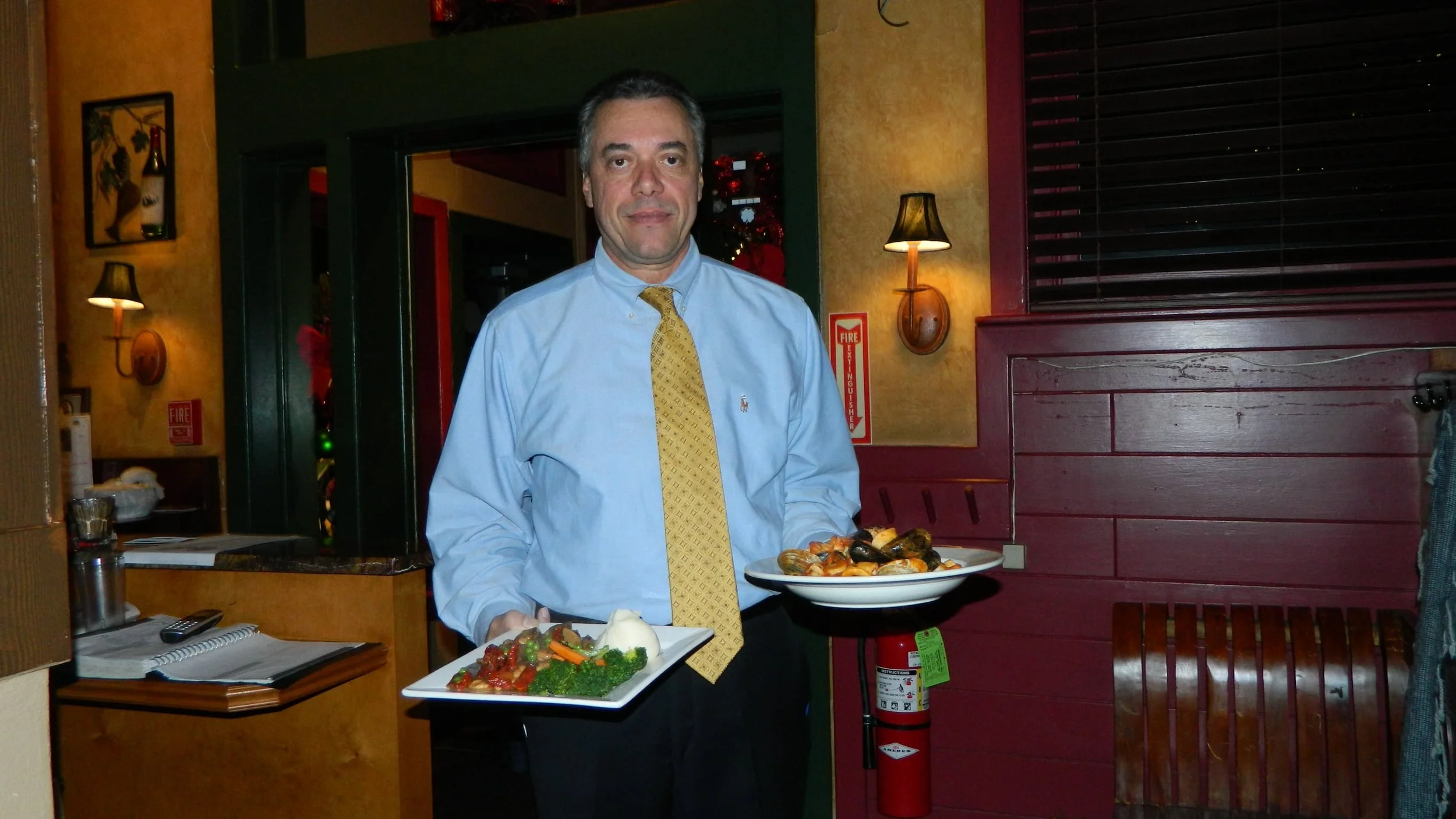 Owner Fernando Murta presents linguine pescatore and pollo alla Nino.