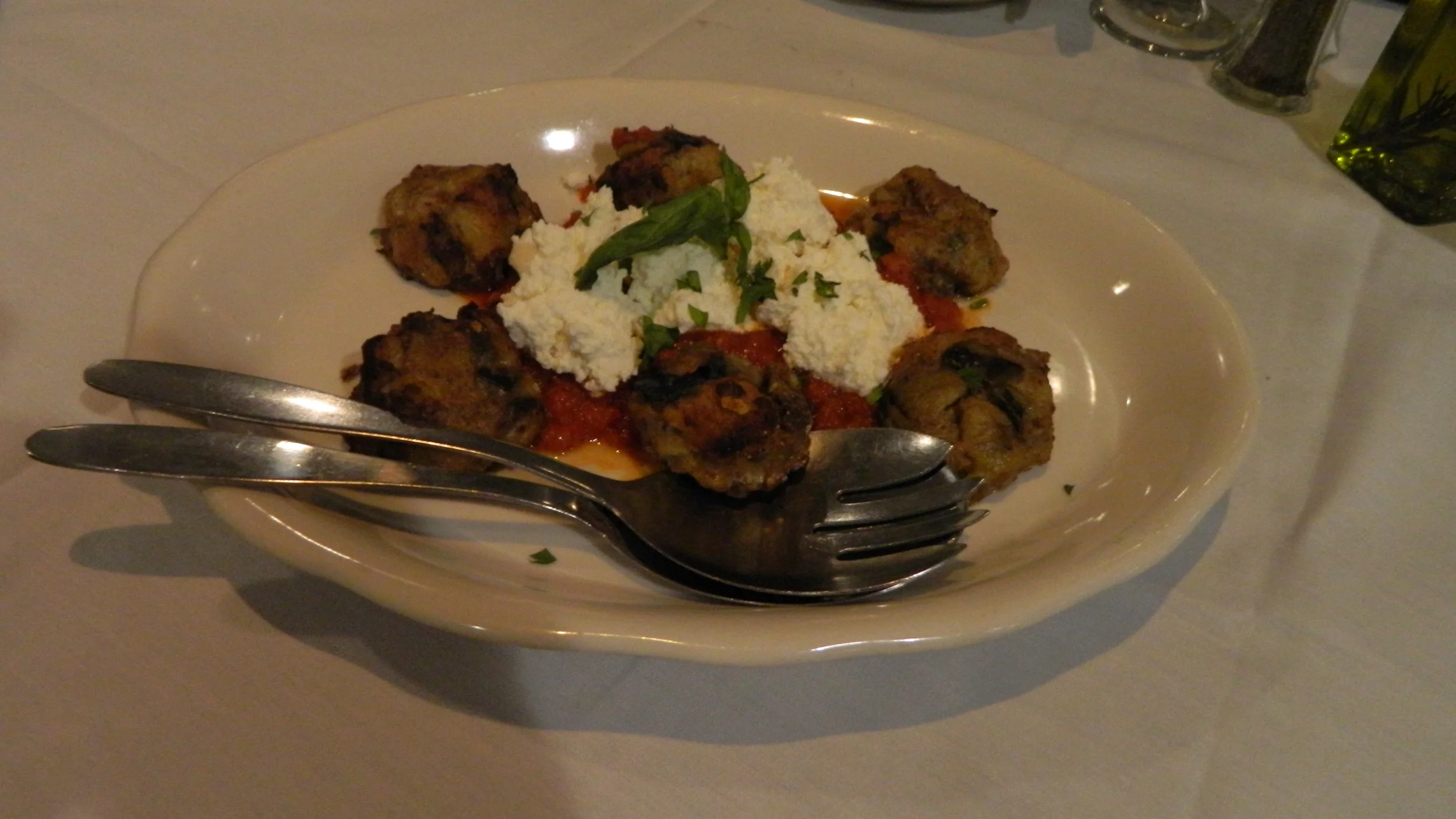 Eggplant balls are an appetizer topped with ricotta cheese and marinara sauce. They’re delicate and lighter than traditional meatballs