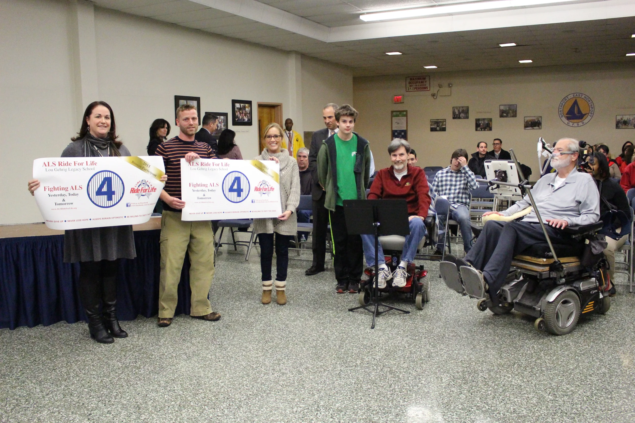 : Representatives of Northport and East Northport middle schools are presented with bronze banners for their schools’ efforts to raise a total of $3,140 toward last year’s Ride for Life, an annual ALS research fundraiser. From left: Northport Middle School Principal Chelsea Brown; John Braun, a East-Northport Middle School science teacher; Theresa Braun, an East Northport Middle School counselor; Ben Strait, Clint Strait, a parent in the Northport-East Northport School District who suffers from ALS; and Chris Pendergast, Ride For Life founder.