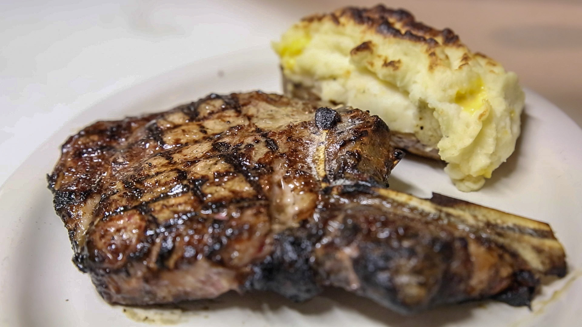 : The bone-in rib eye steak at The Clubhouse is served with a stuffed baked potato.