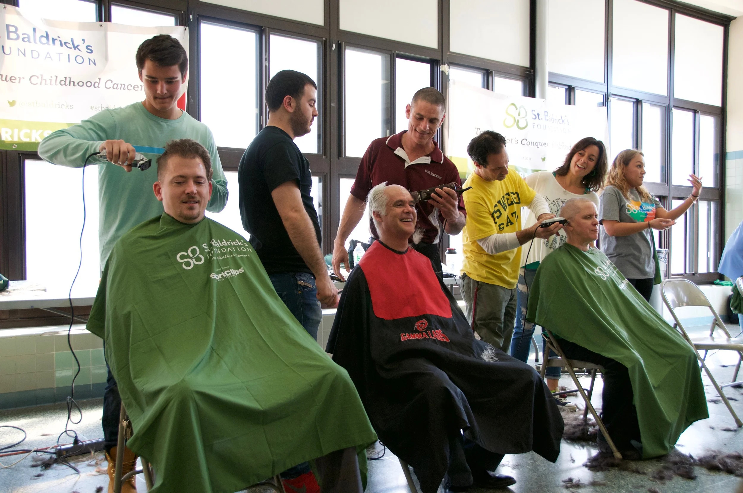 Walt Whitman High School Principal John Murphy and South Huntington Teachers Association President Dennis Callahan join, on Wednesday, the annual St. Baldrick’s shavathon at Walt Whitman High School.