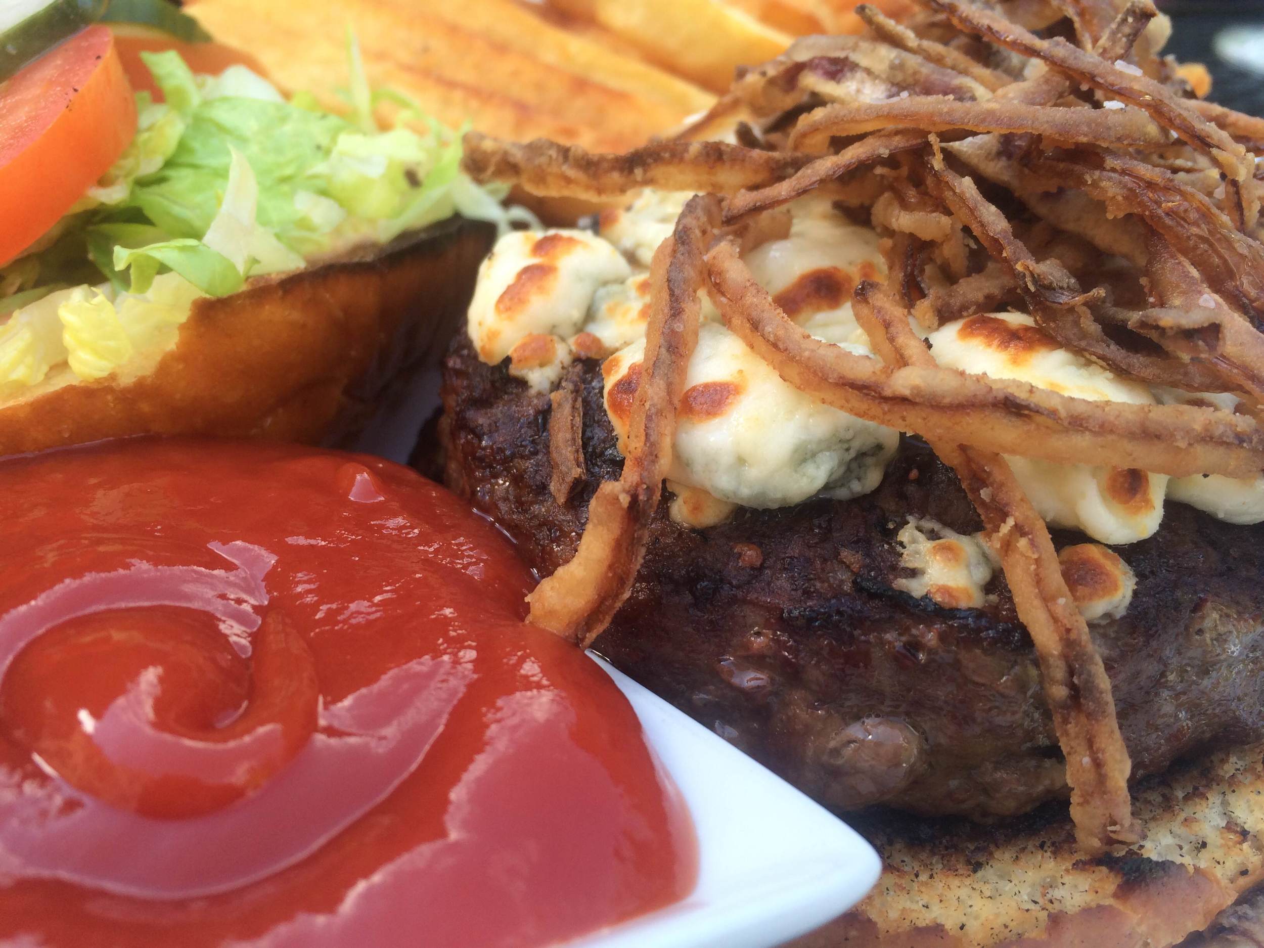 The Kobe short rib beef burger at Bistro 44 is served on a brioche bun with Stiton bleu cheese, Applewood bacon, frizzled onions, shredded lettuce, and with French fries for $14.50 on the lunch menu.
