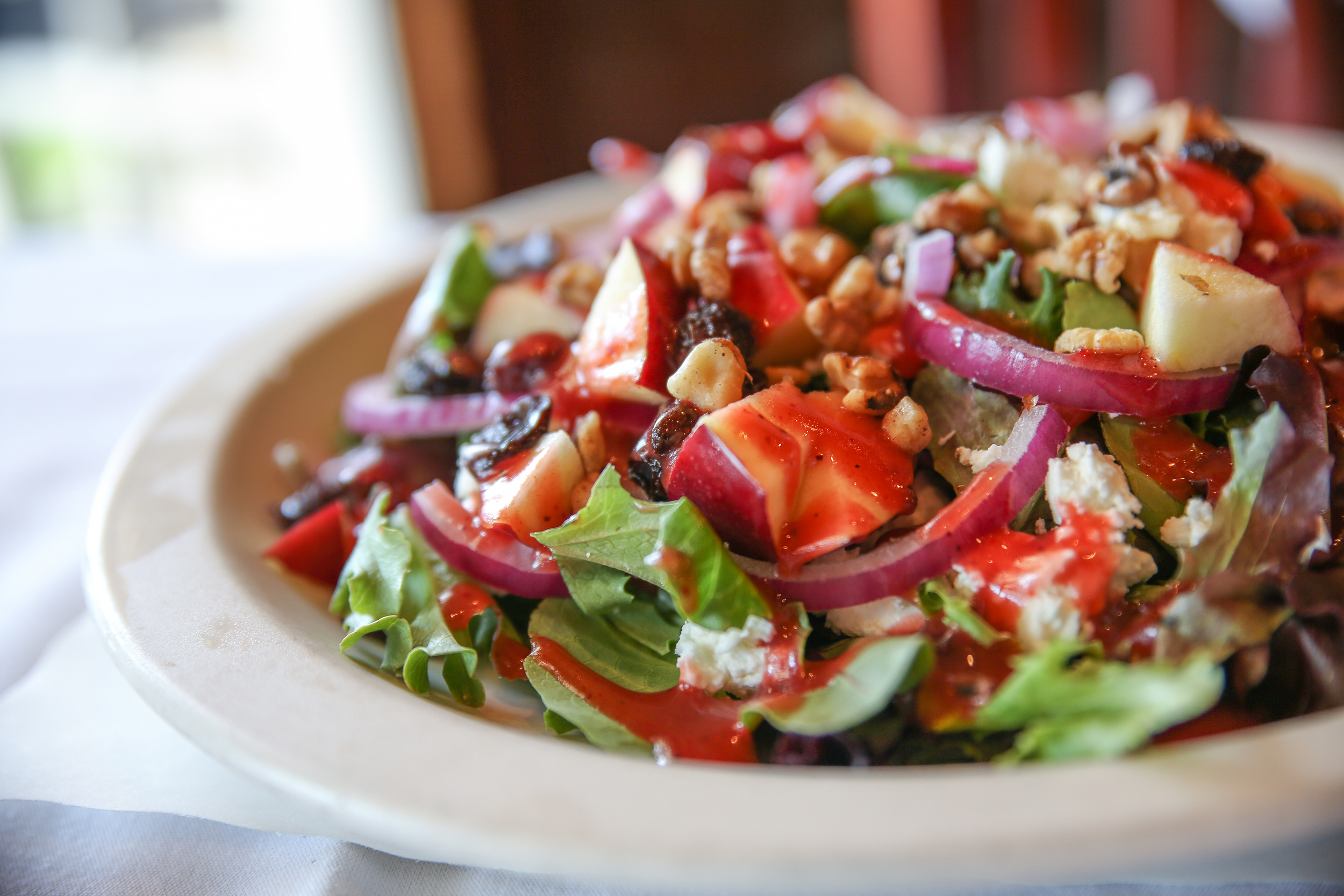The Goat Cheese and Apple Salad goes toe-to-toe with the generous entrees, bringing the richness of goat cheese, balanced with toasted walnuts, raisins, lettuce and red onions topped with a light and springy raspberry vinaigrette.
