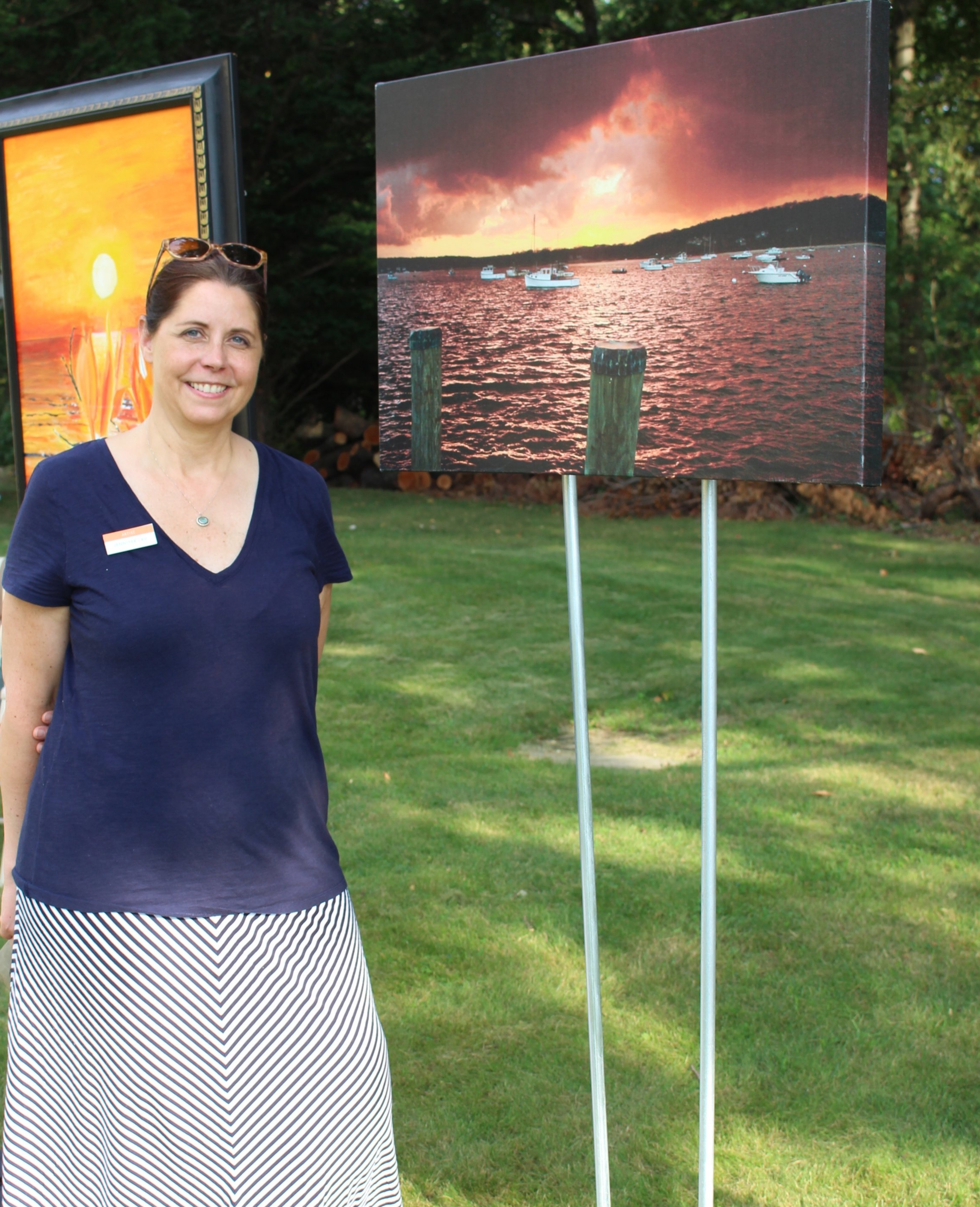 Long Islander News photos/Janee Law Jennifer Lau, managing partner of Northport-based gallery Firefly Artists, stands next to her photograph called “Winter Sunset,” which she shot in January. 