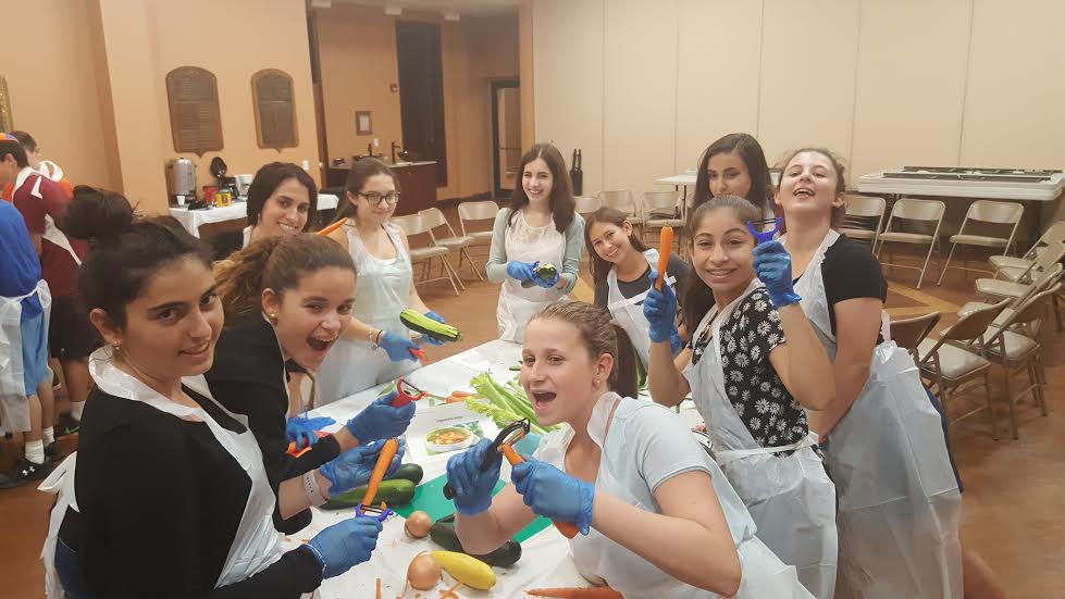 Teens in the CTeen chapter at Dix Hills’ Chai Center cook up meals for needy families on Sept. 22.