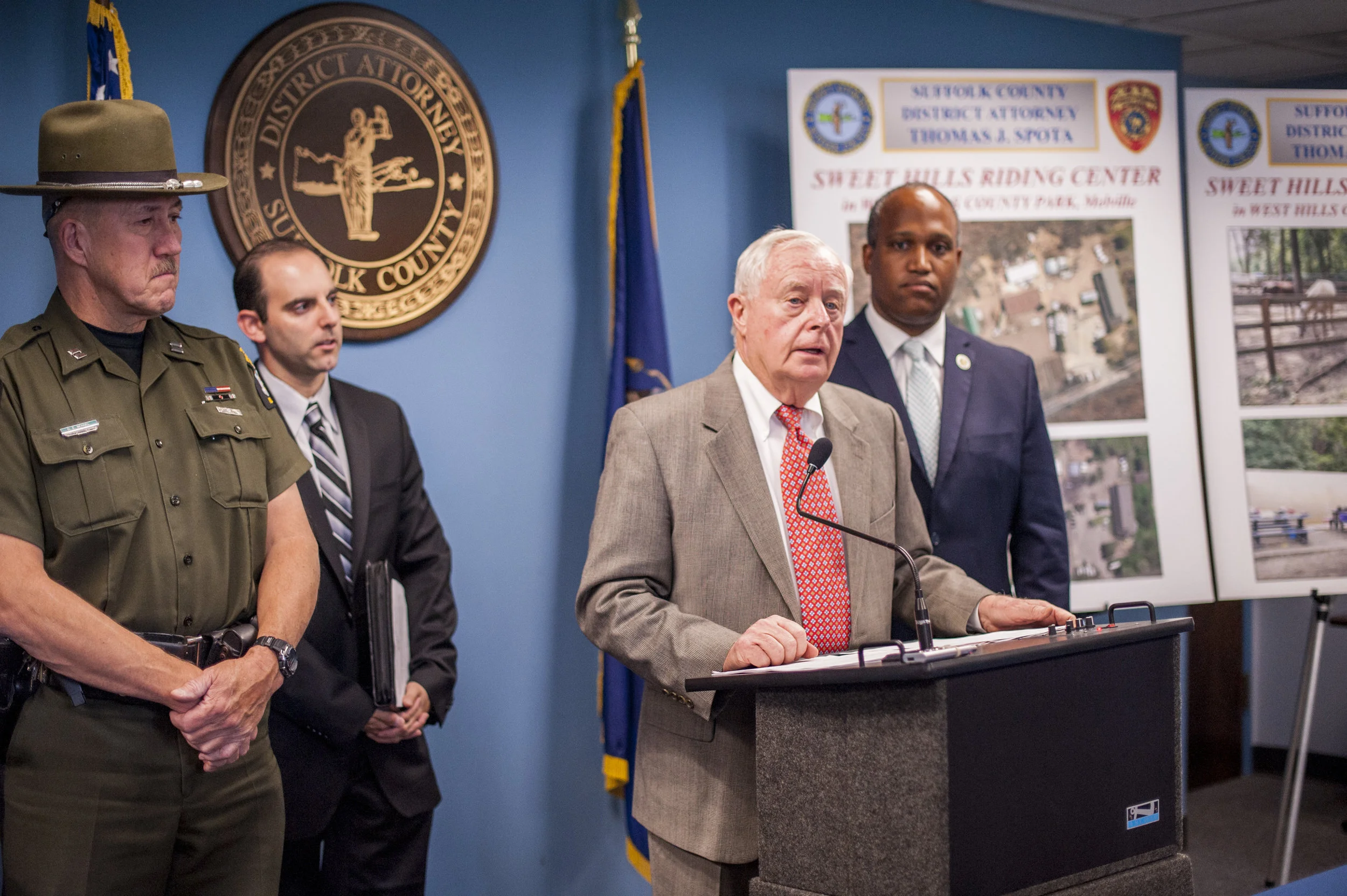 Suffolk District Attorney Thomas Spota announces the severe contamination of the Sweet Hills Riding Center in Melville’s West Hills County Park. He compared aerial images that depict the areas where contaminants were dumped.