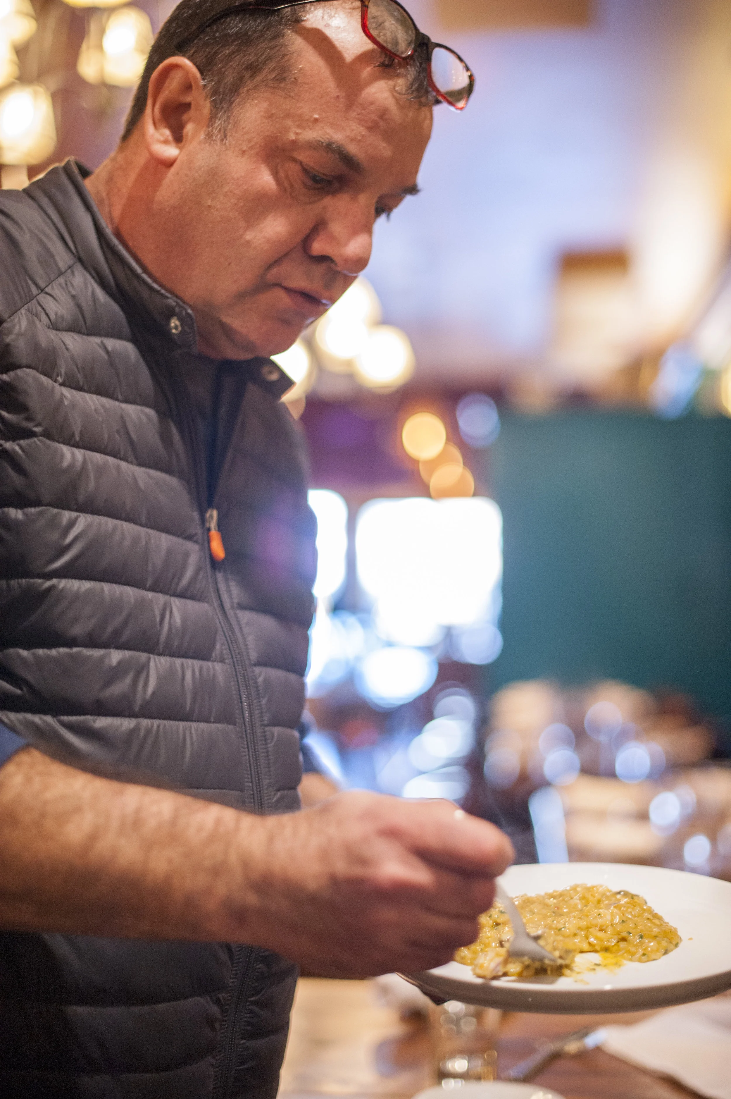 Nino Antuzzi, owner of Osteria Da Nino, samples a seafood risotto to ensure the finest quality in his cuisine.
