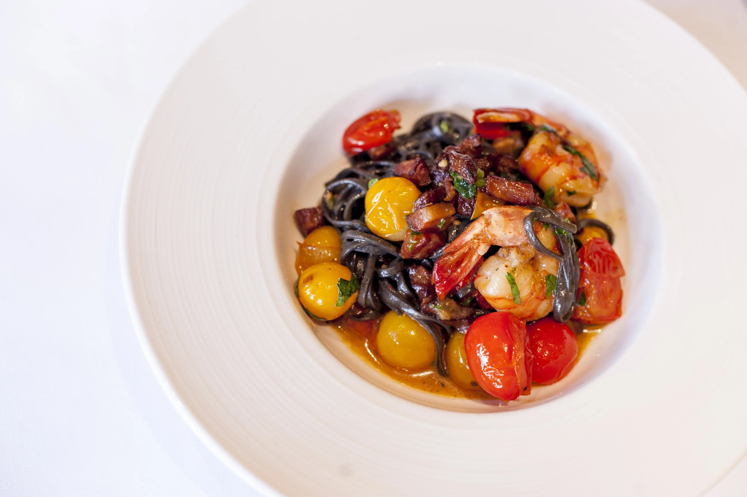 The Linguini Neri is a medley of shrimp, squid ink linguini, pancetta and red and yellow grape tomatoes, which burst with a fresh zest.