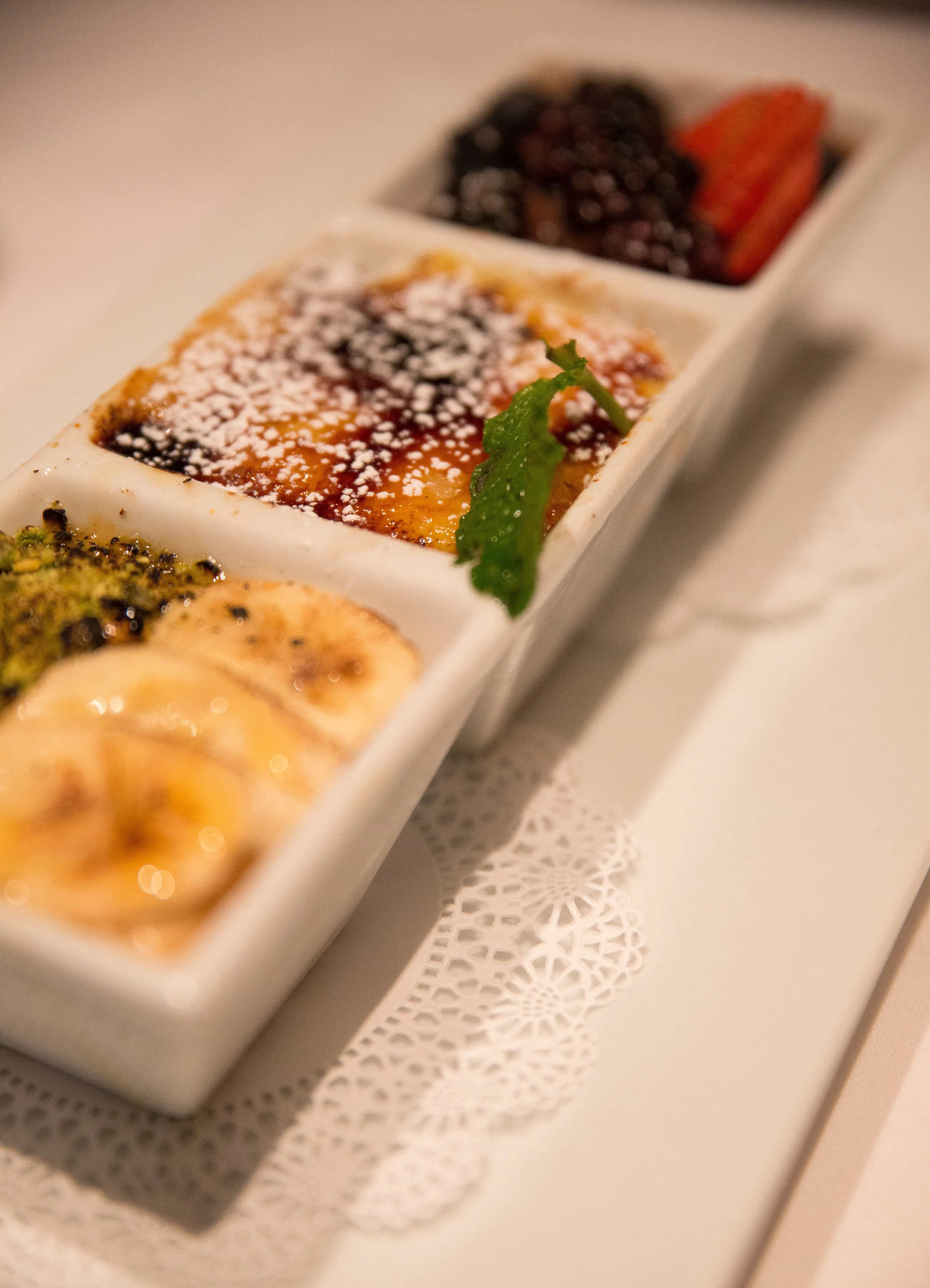 The triple Creme Brulee brings together the classic creme brulee, another one that is mango flavored and topped with banana and ground pistachio and a third that’s blended with chocolate and is topped with blueberries, blackberries and strawberries. (Photo / Craig D'Andrea).