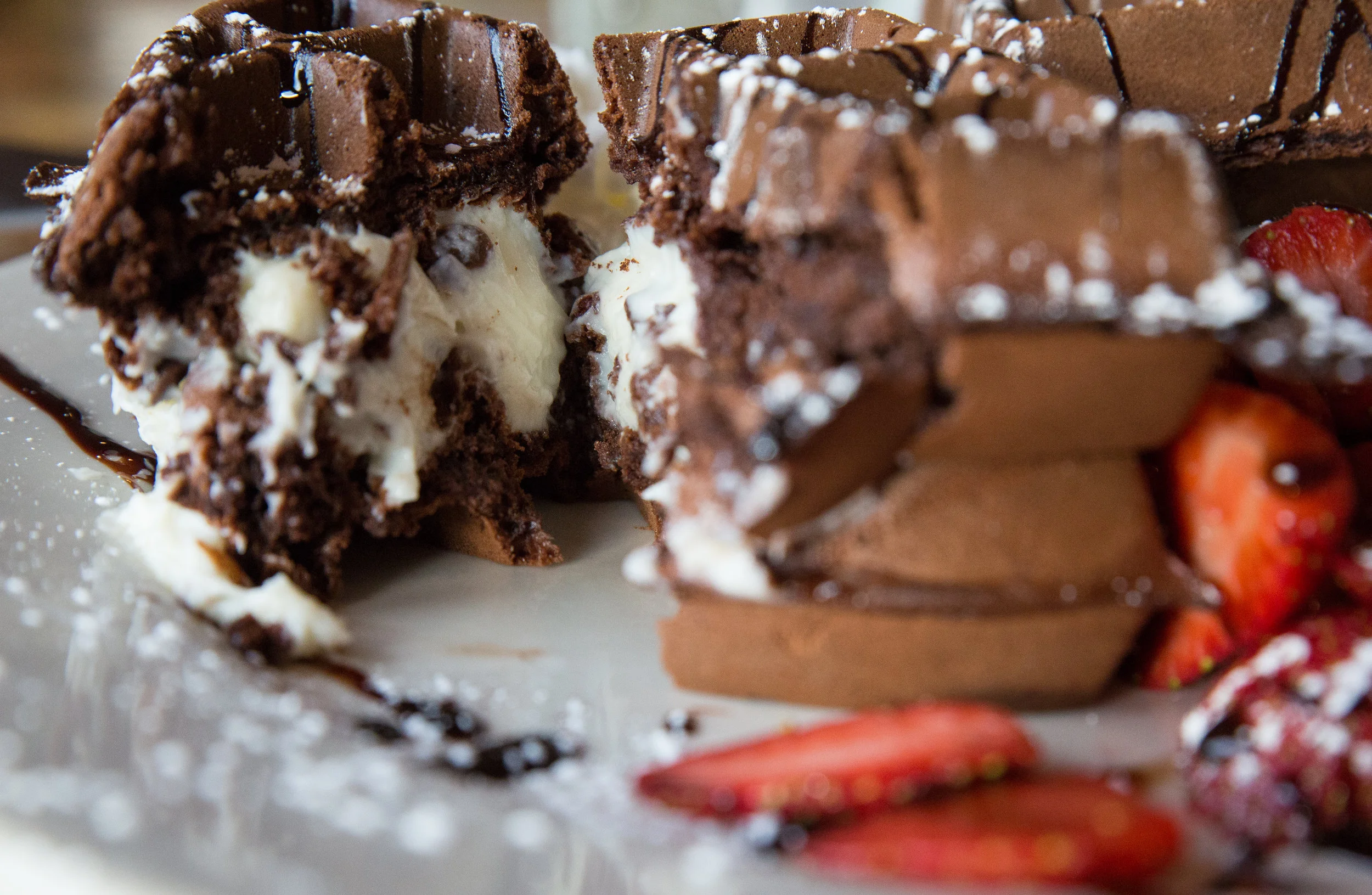 The Chocolate Stuffed Cannoli Cream Waffle is a chocolaty take on the Italian staple dessert and is served with cut strawberries and whipped cream for a fruity and creamy mix of delights.