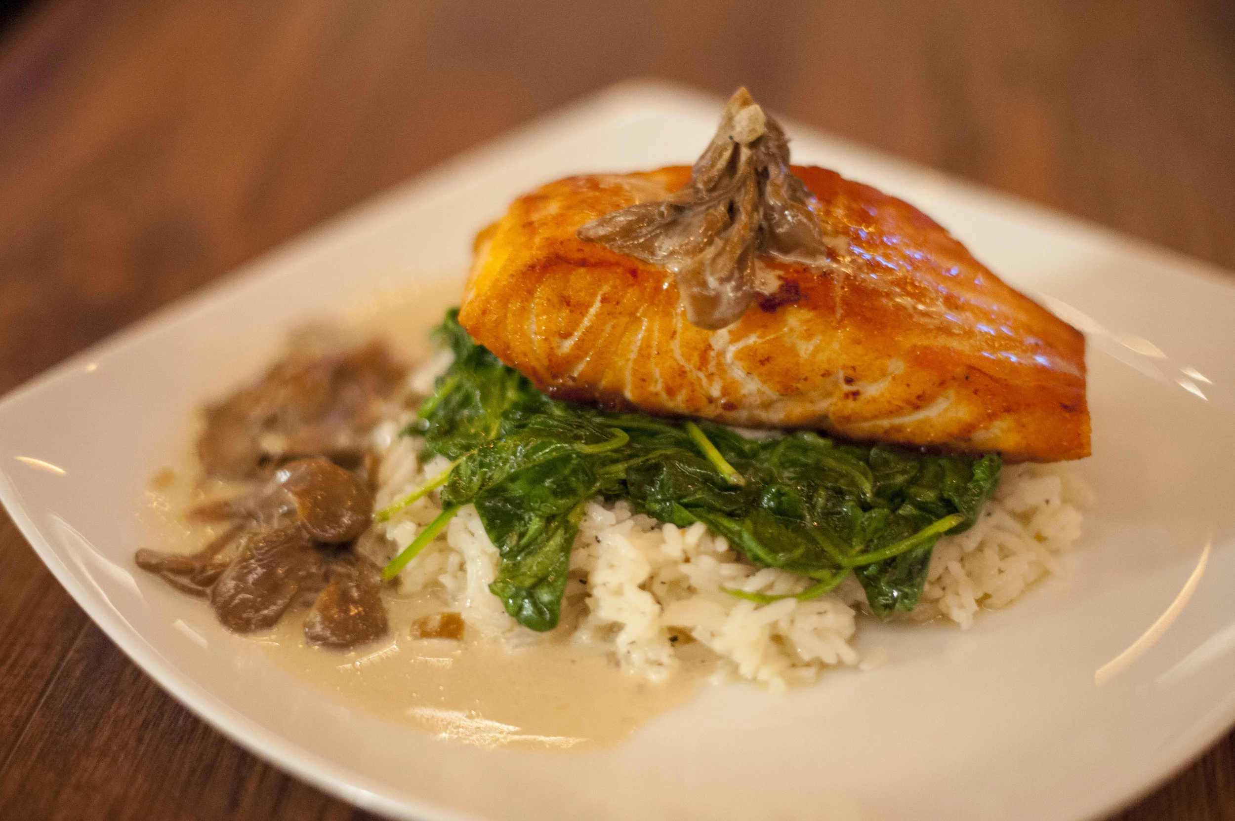 The Roasted Salmon Filet at Crabtrees, served on a bed of spinach and jasmine rice, is served with maitake mushrooms and an Irish cream sauce that makes this a true comfort meal.