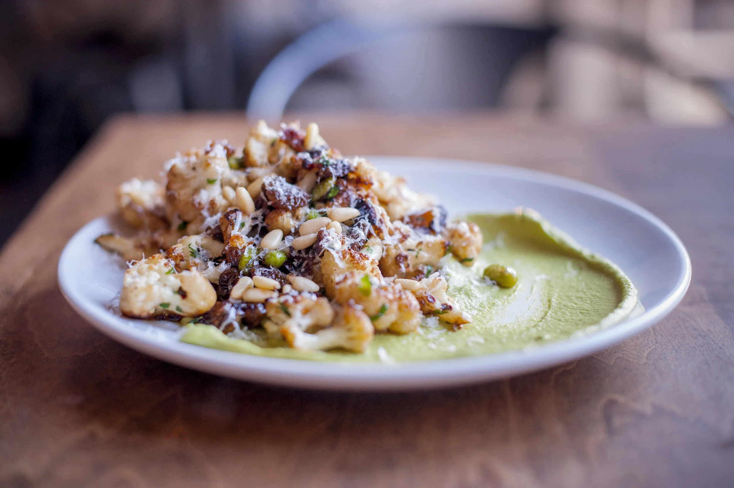 Swallow’s Roasted Cauliflower brings together edamame, golden raisins, pine nuts and pea puree for a contrasting collage of sweet, savory and nutty flavors.