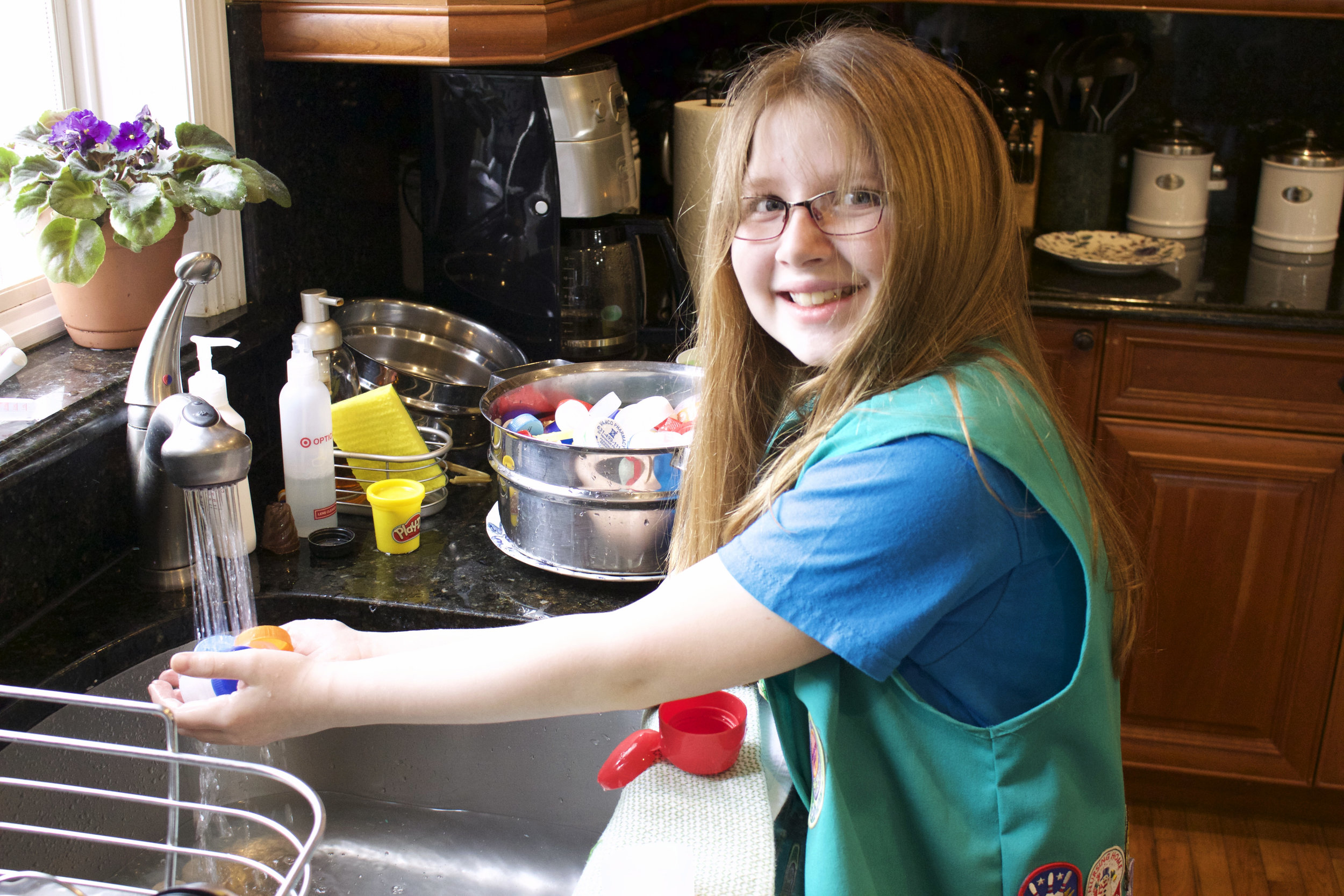  After the plastic caps and lids are sorted through the bags, they are passed to Judy Reilly, 9, who thoroughly washes each plastic cap and lid. 