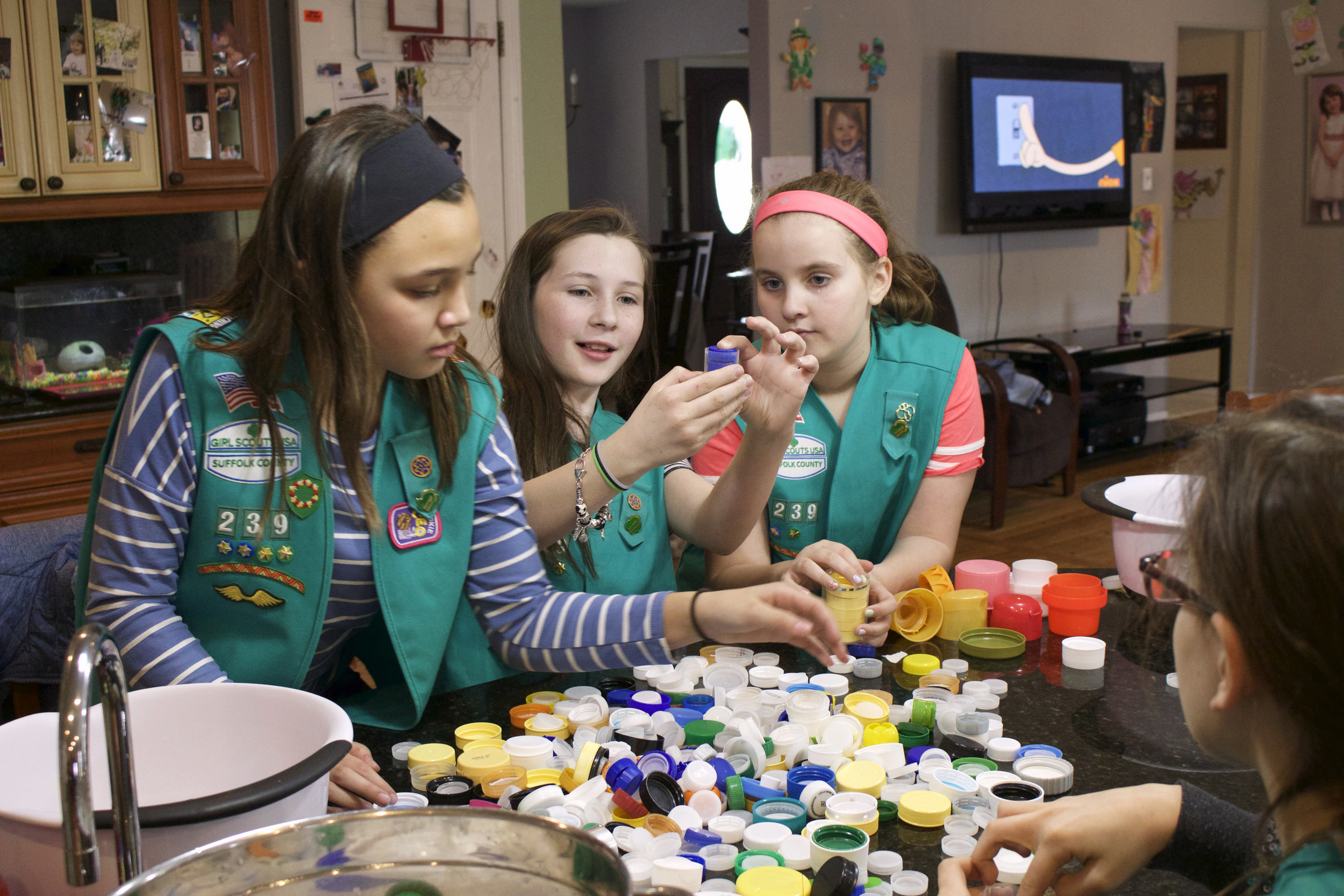  Lindsay Alms, 10, Ciara Coleman, 9, and Evelyn McGorry, 9, examine each plastic cap and lid to make sure they are acceptable to be made into a bench.    